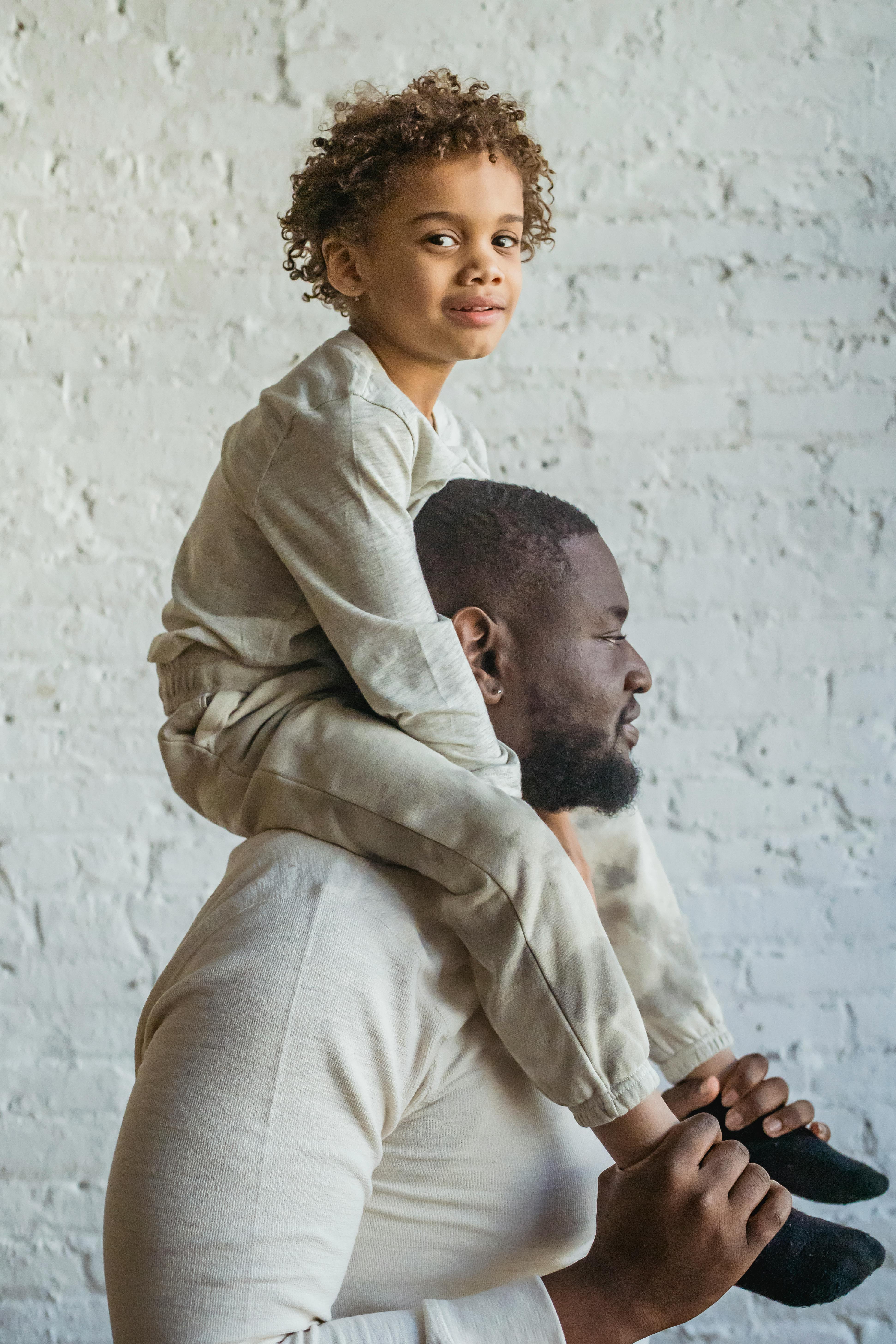 black man carrying cute son on shoulders