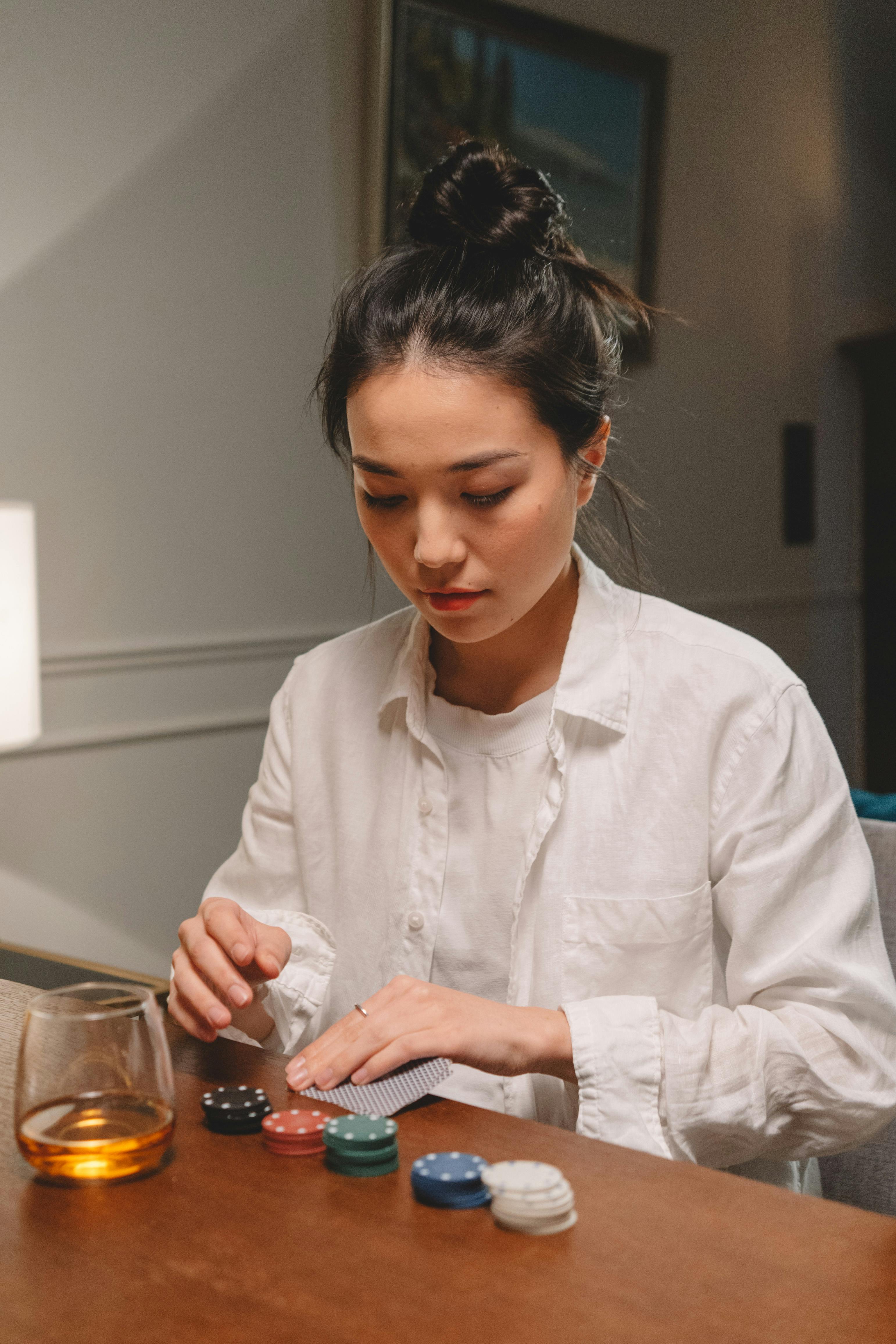 woman in white long sleeves holding poker cards