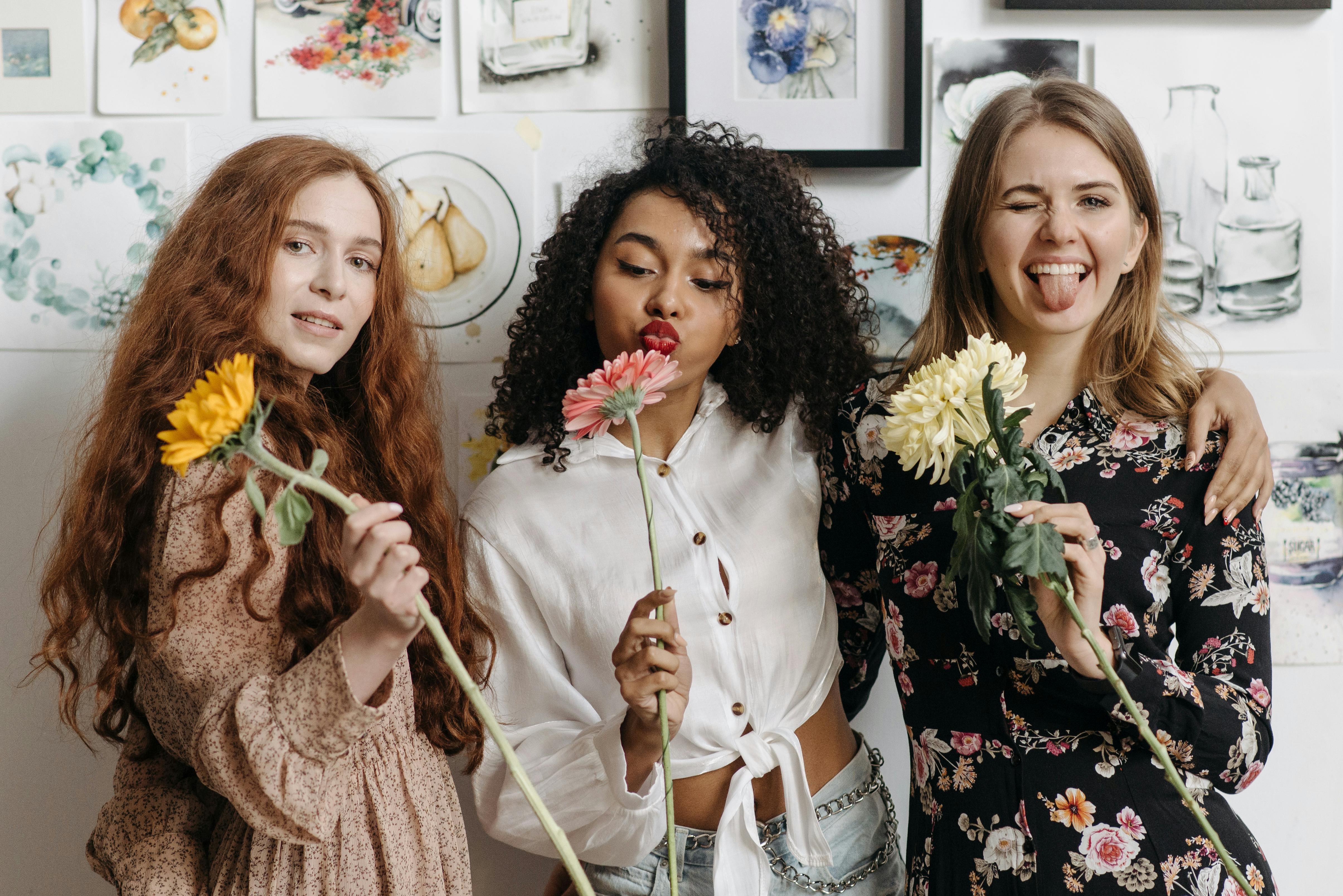 3 women holding flowers