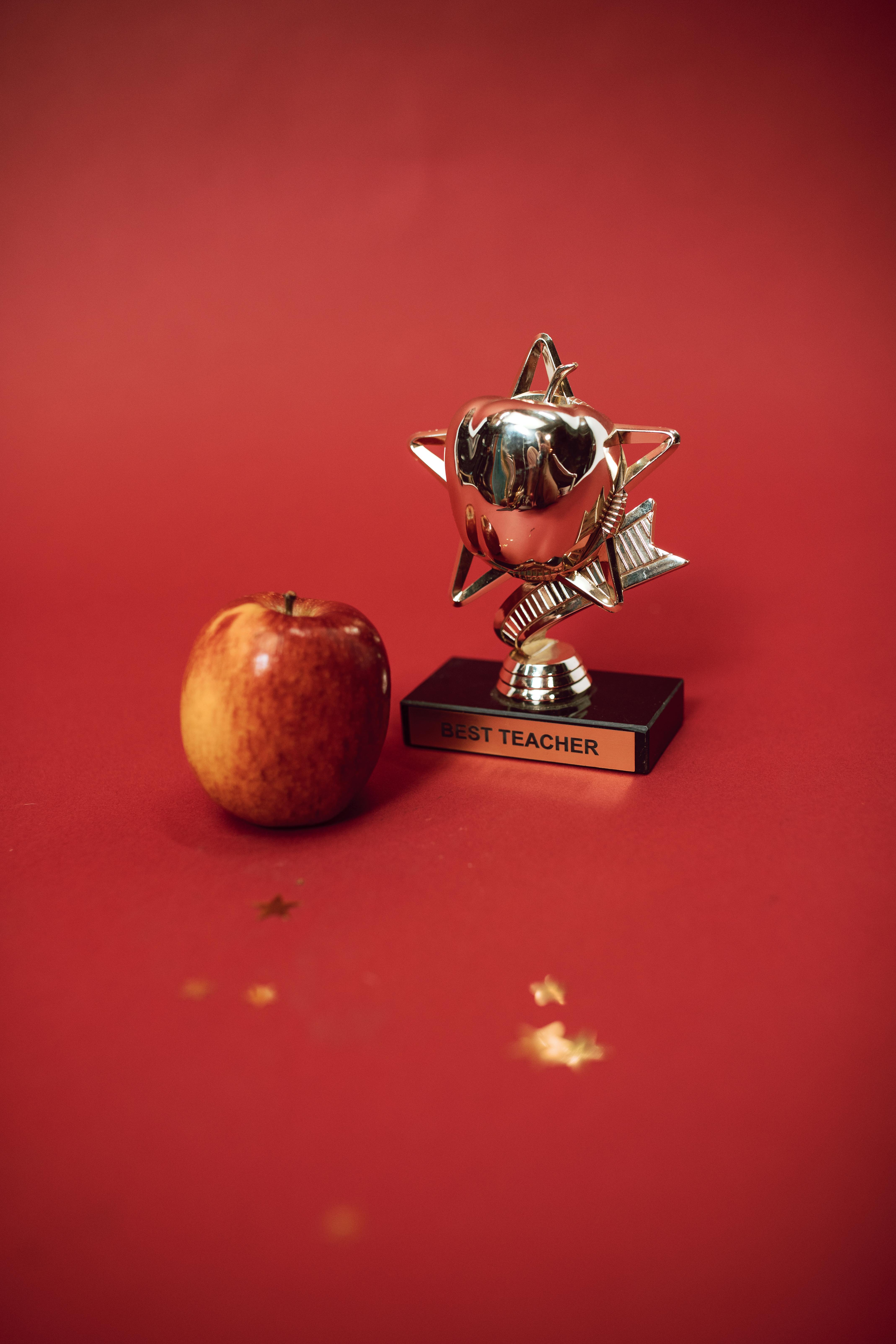 an apple and a best teacher trophy