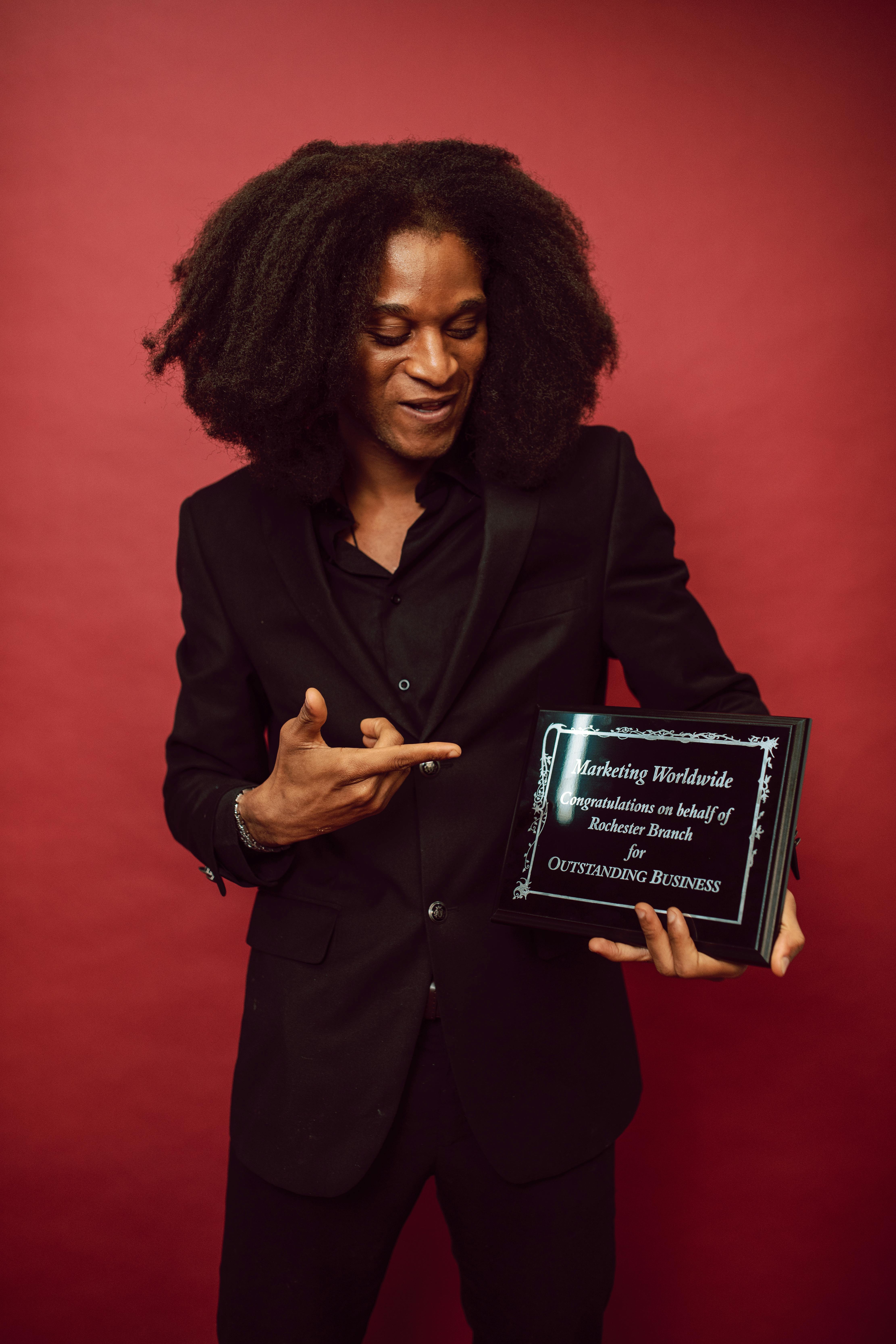 a proud businessman pointing at his award