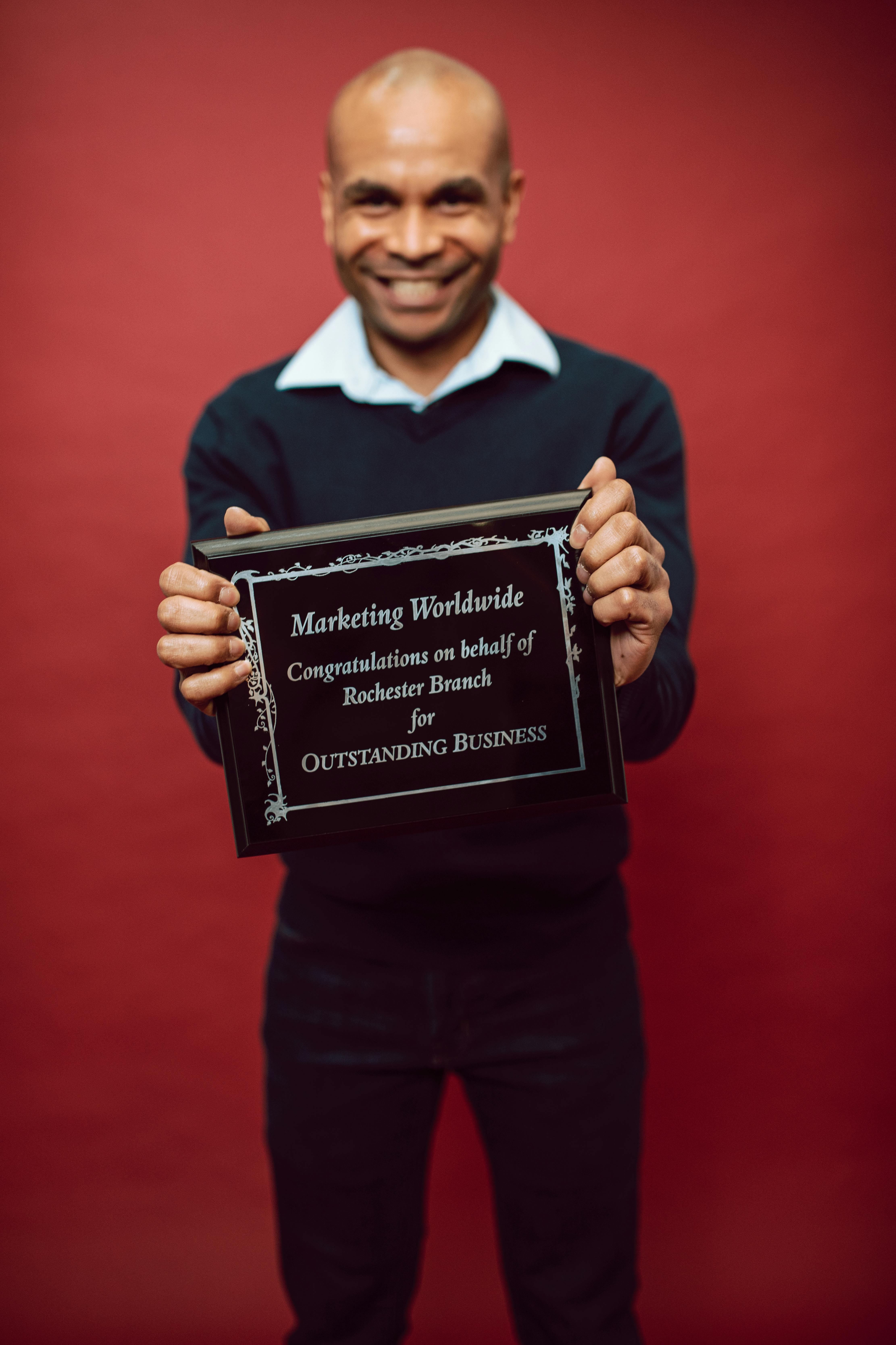 a proud man showing his recognition award