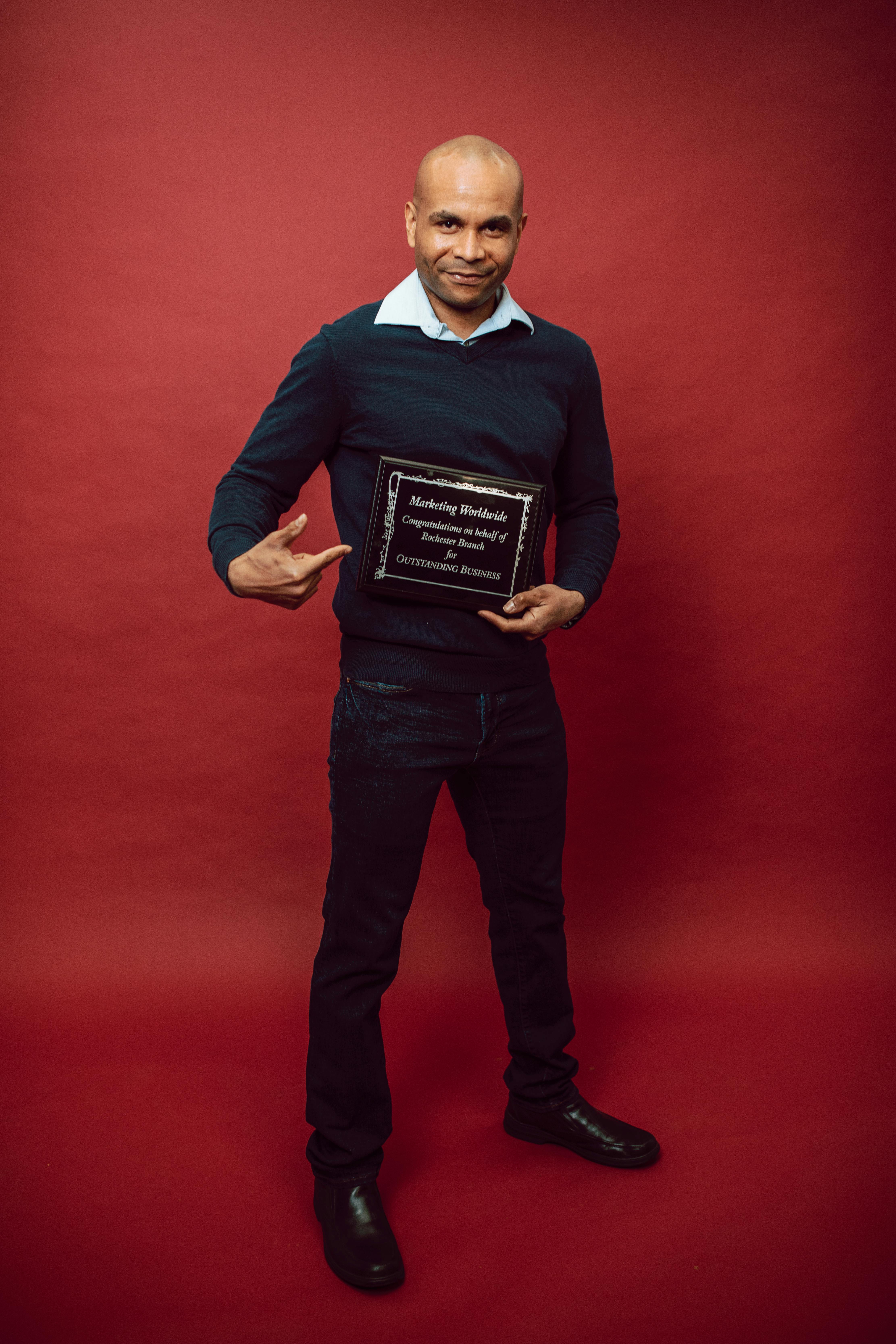 a man pointing at his recognition award