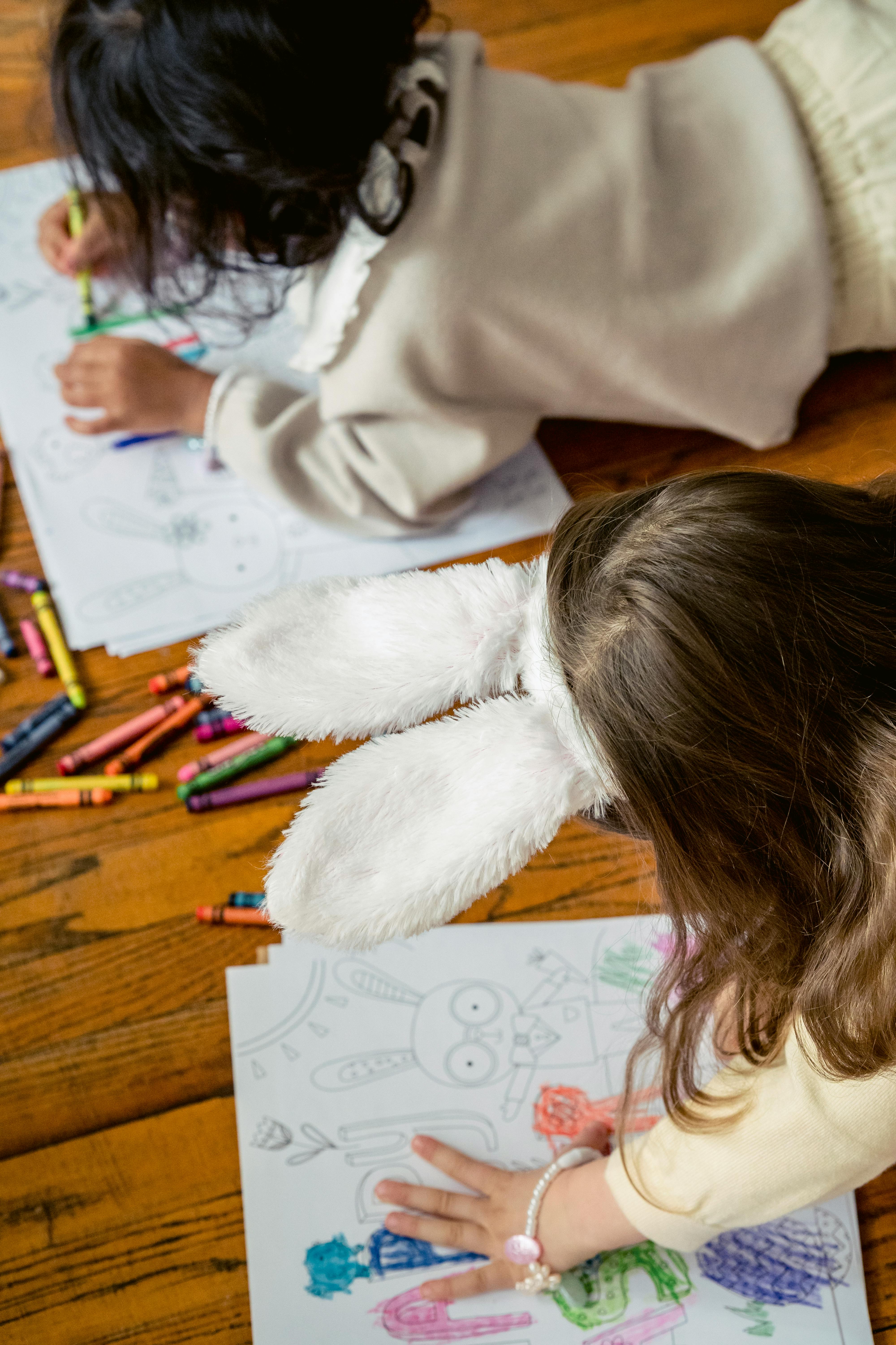 anonymous children drawing easter eggs and letters on papers