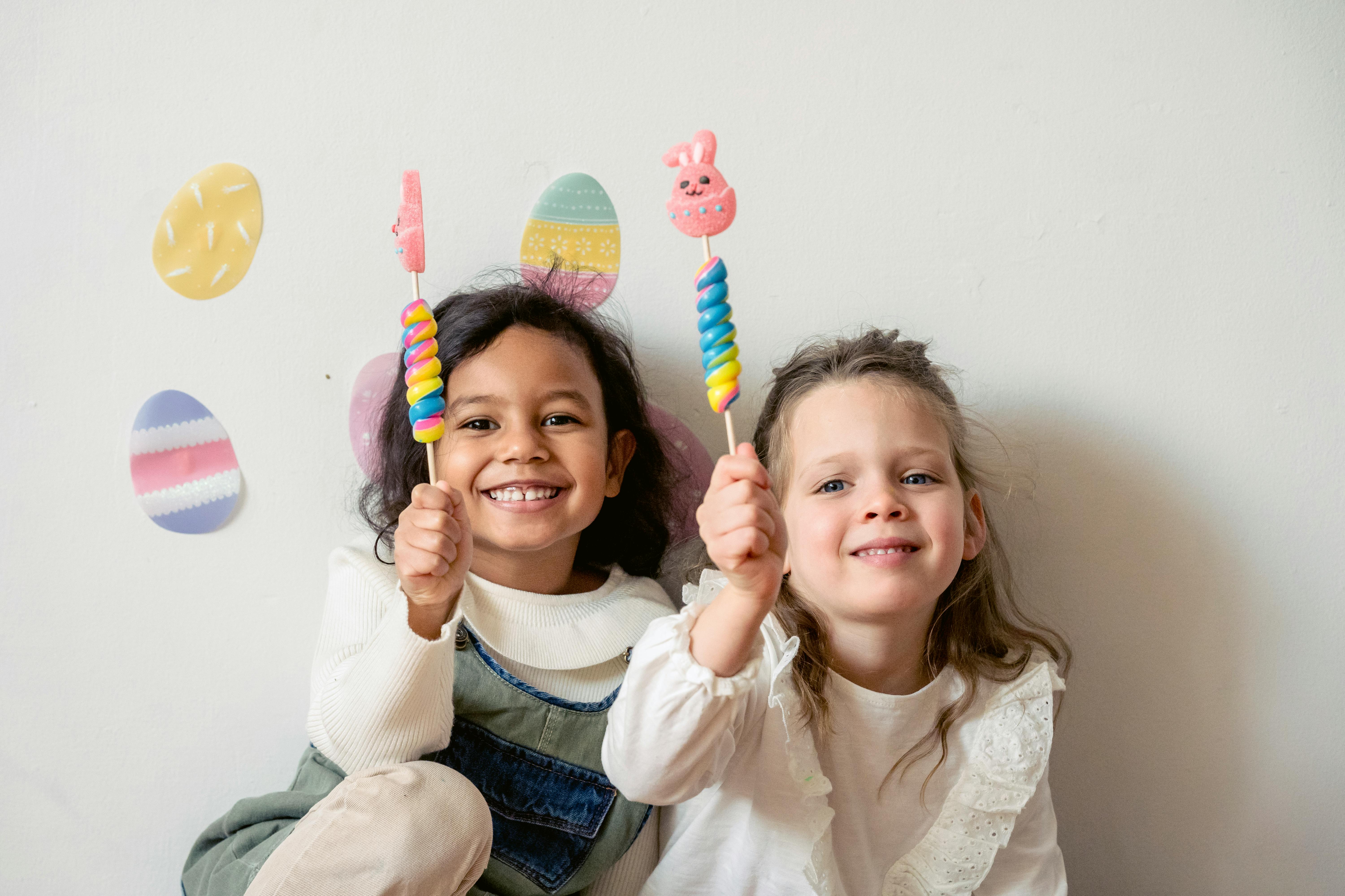 happy diverse girls with easter lollipops