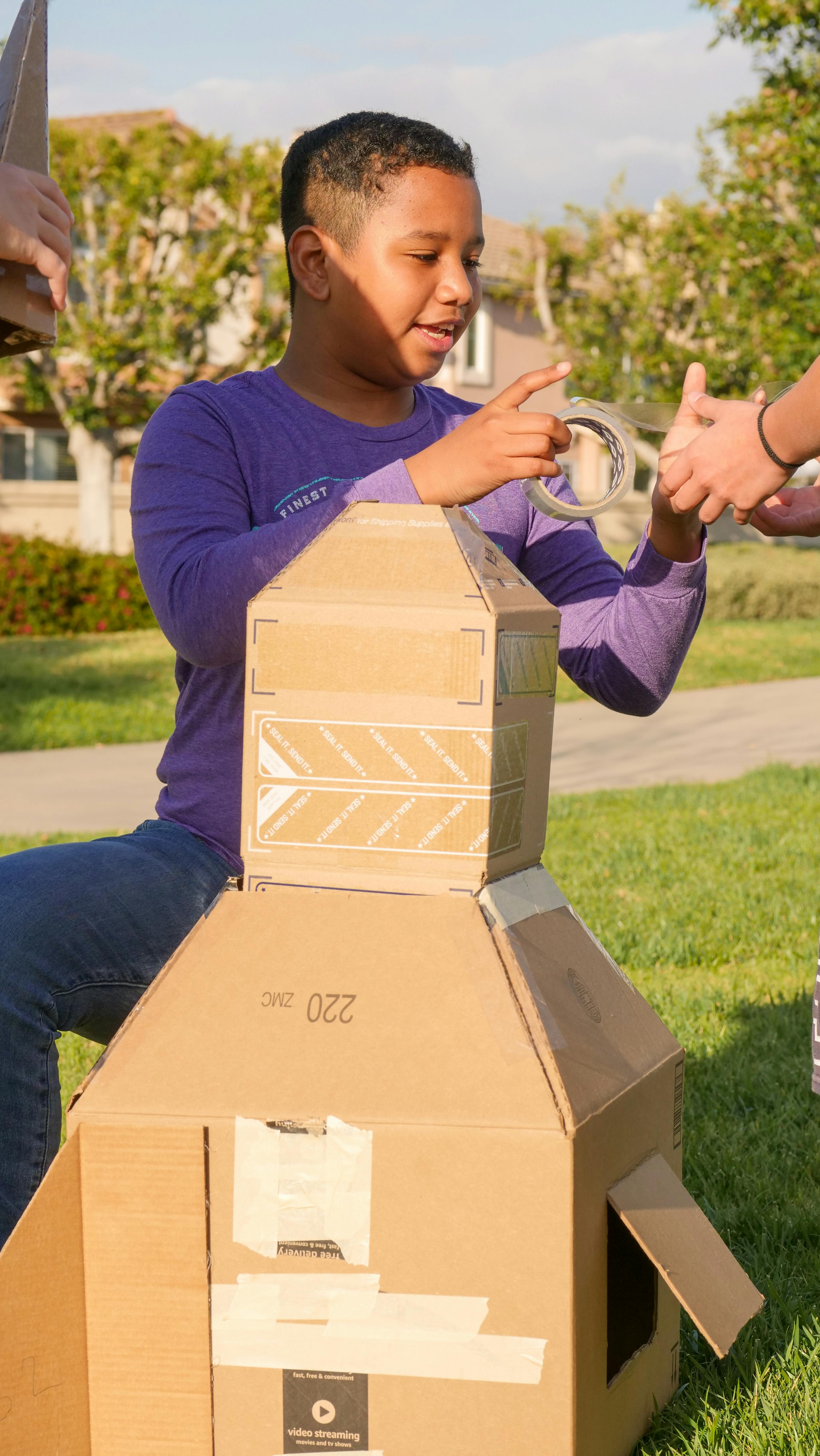 a boy making a cardboard rocket