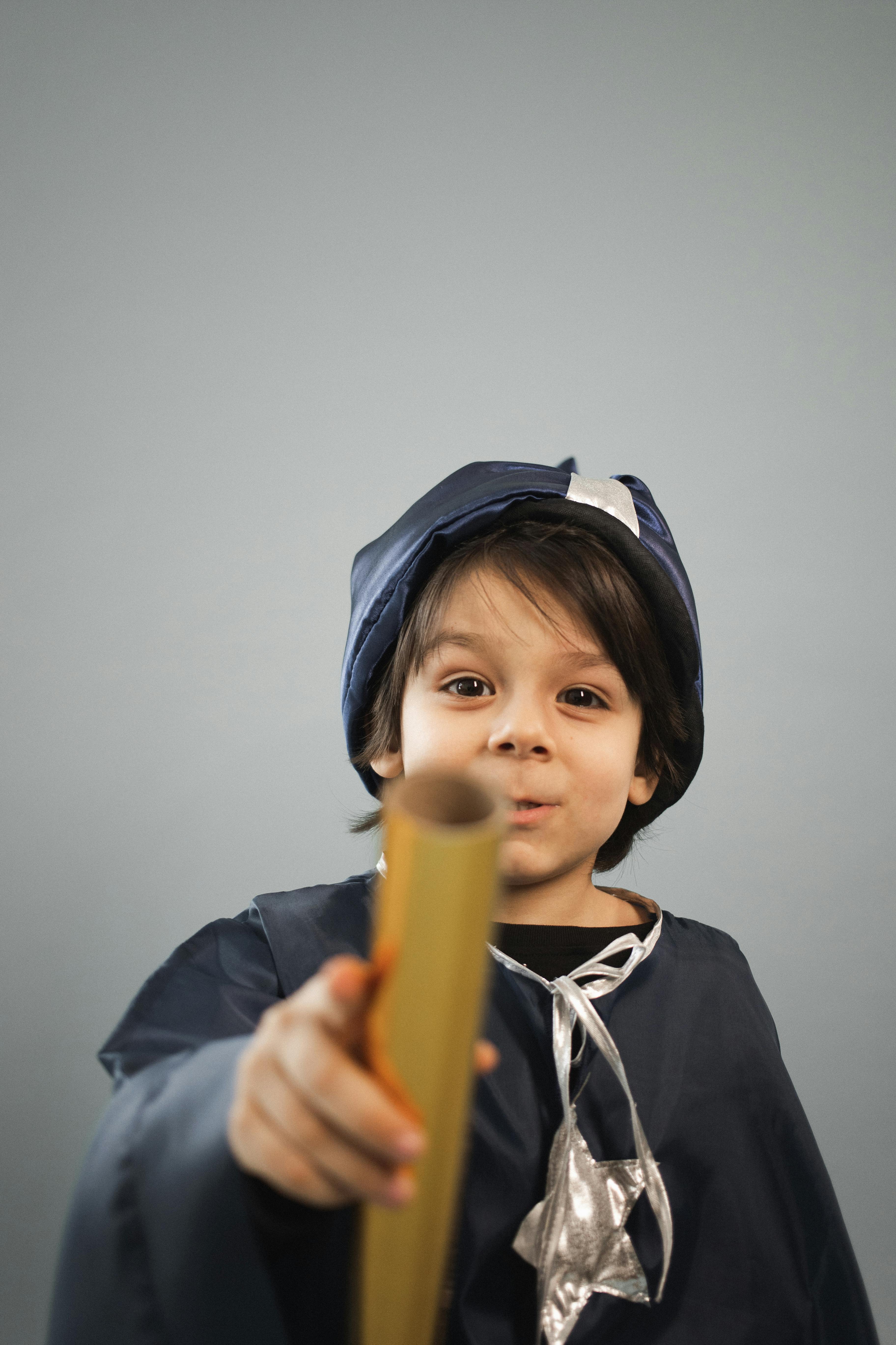 charming boy in astrologer costume with spyglass