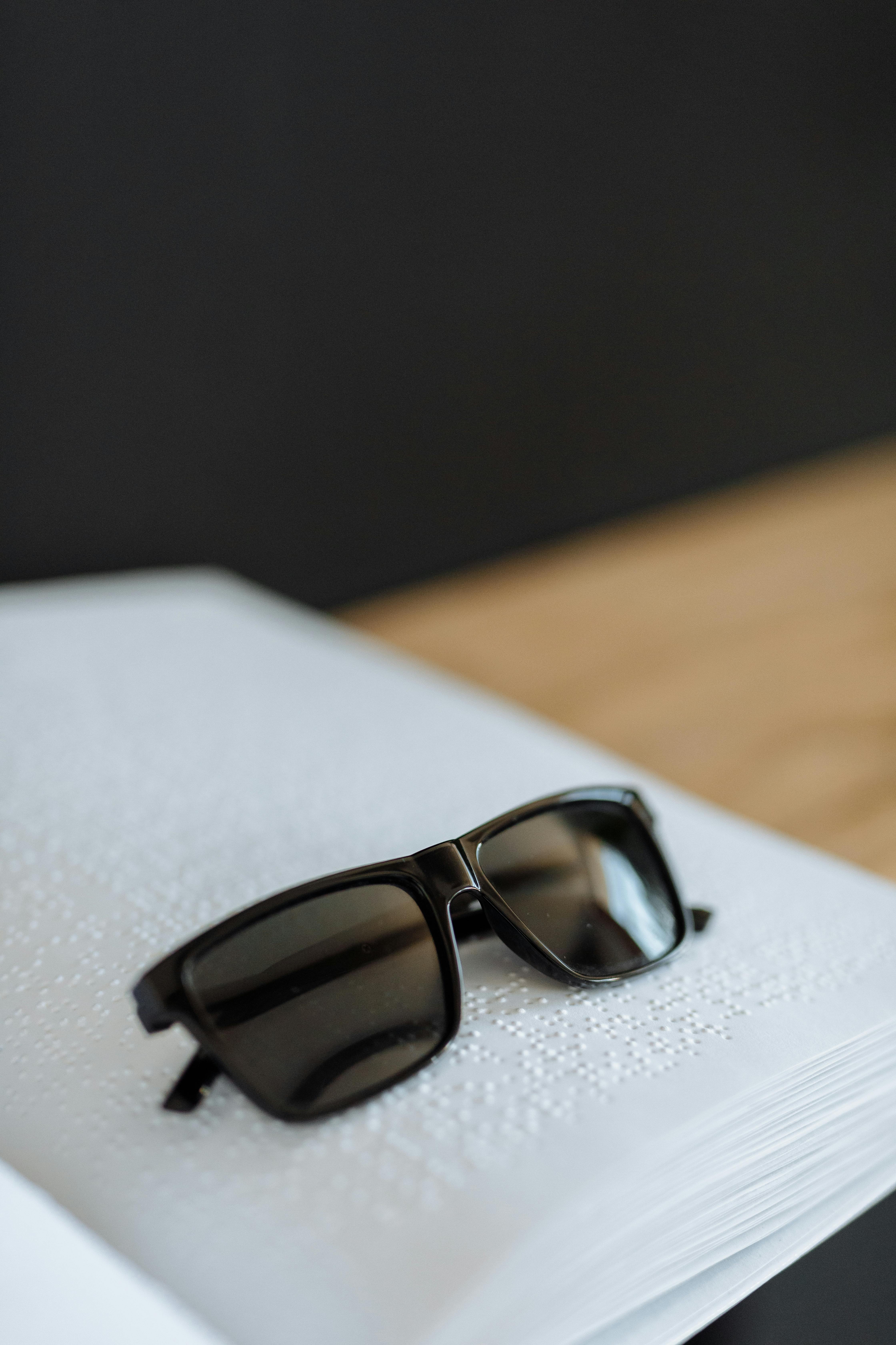 a pair of sunglasses on a braille book