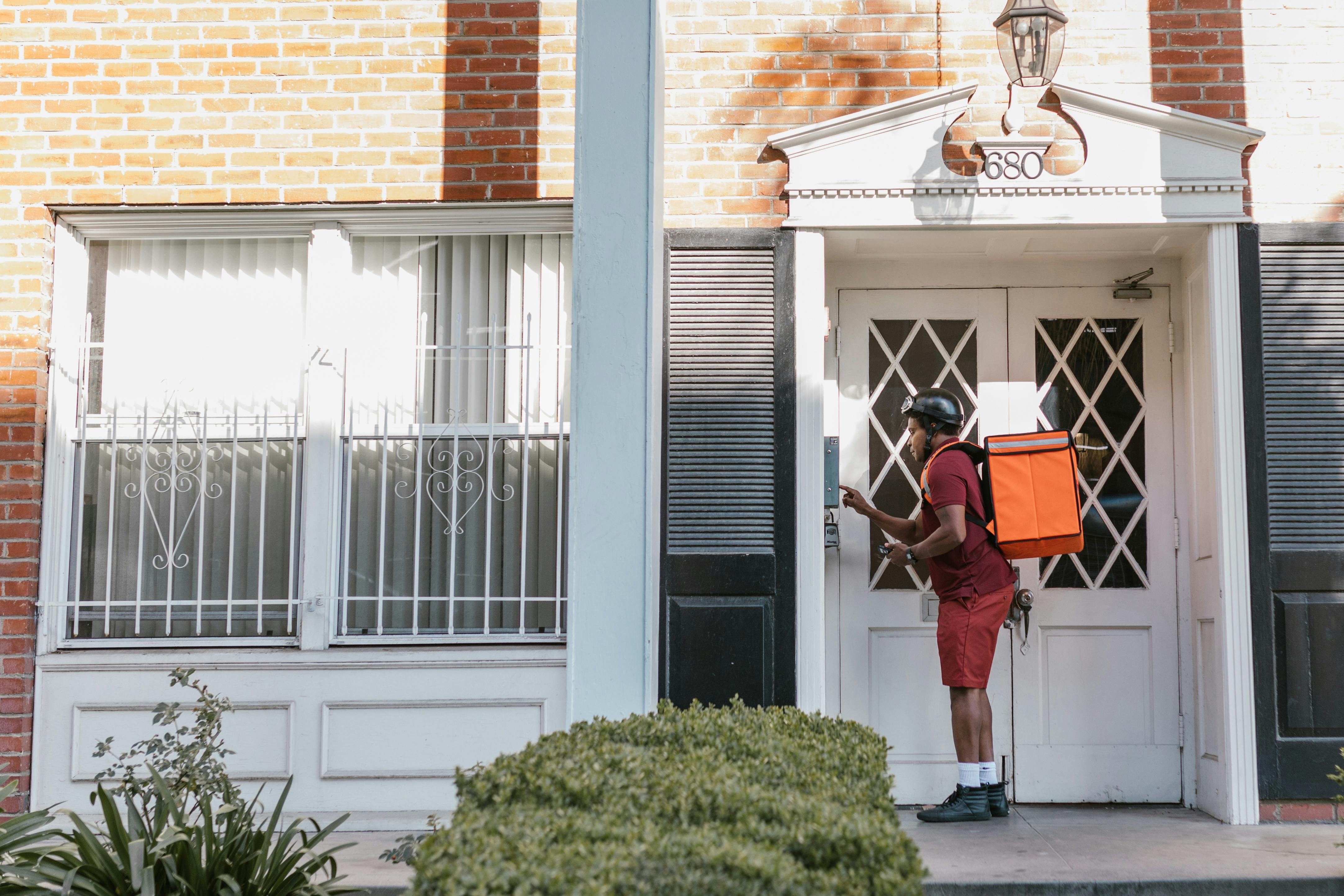 a deliveryman pressing the doorbell