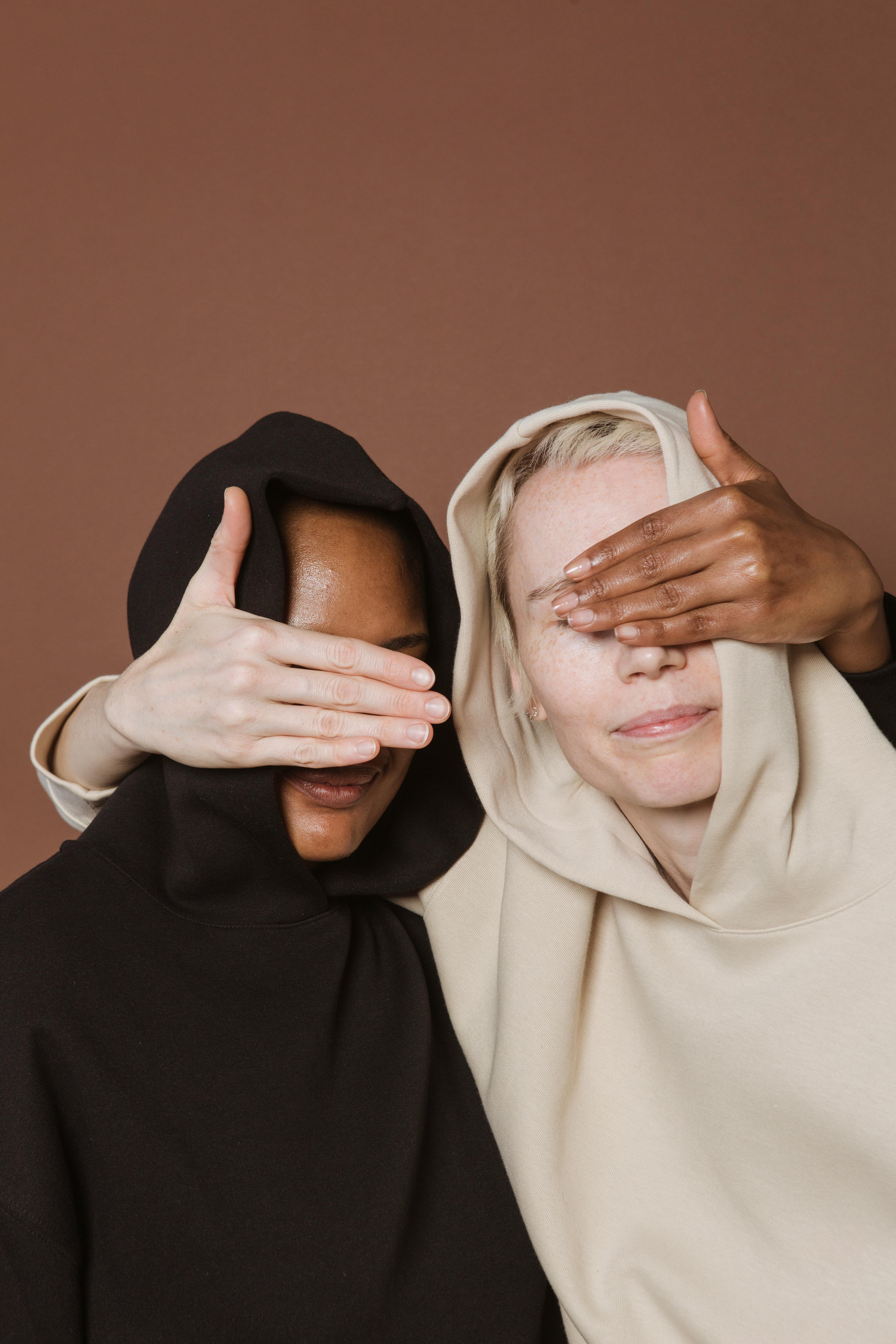 calm women covering eyes of each other