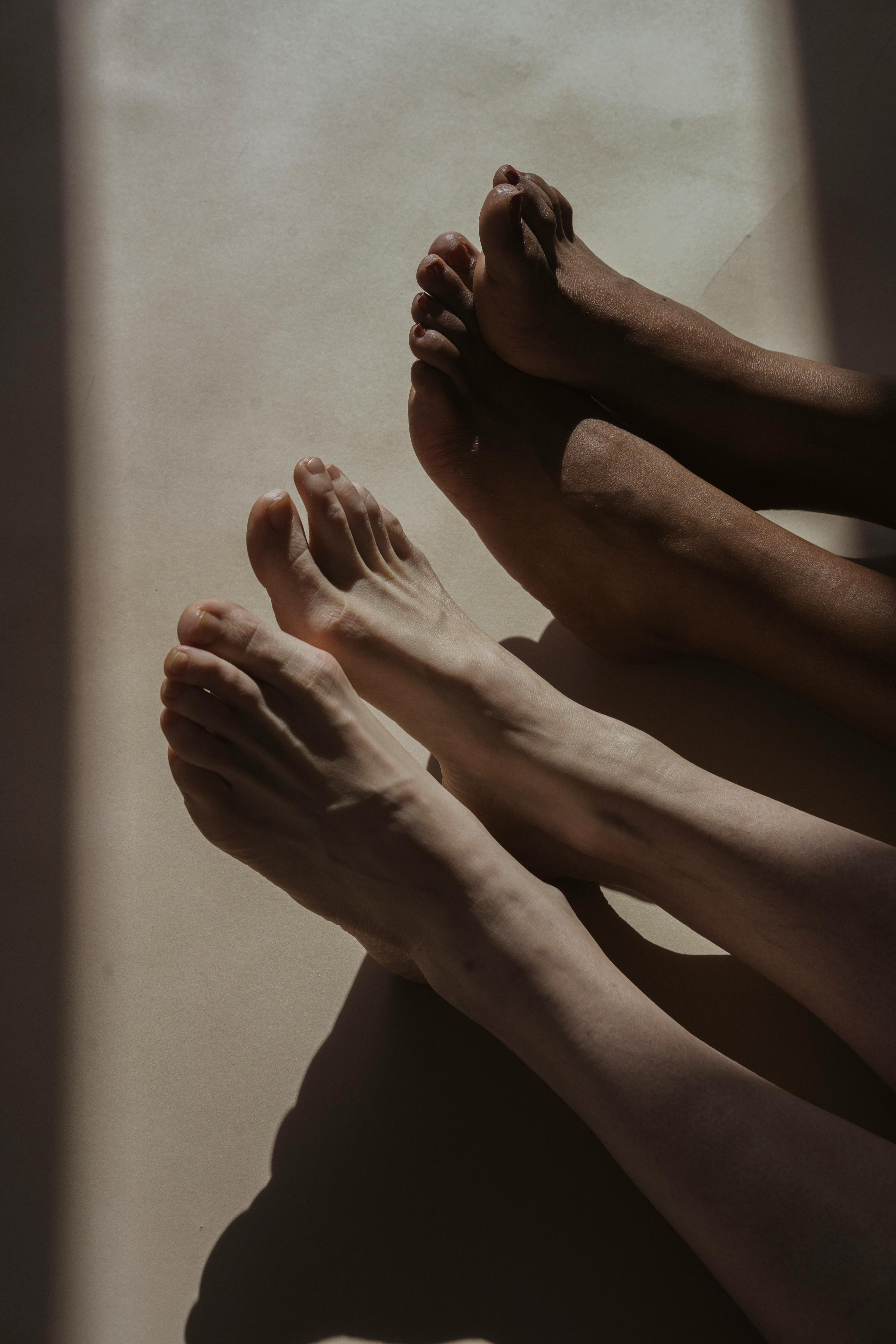 bare feet of crop diverse people on floor