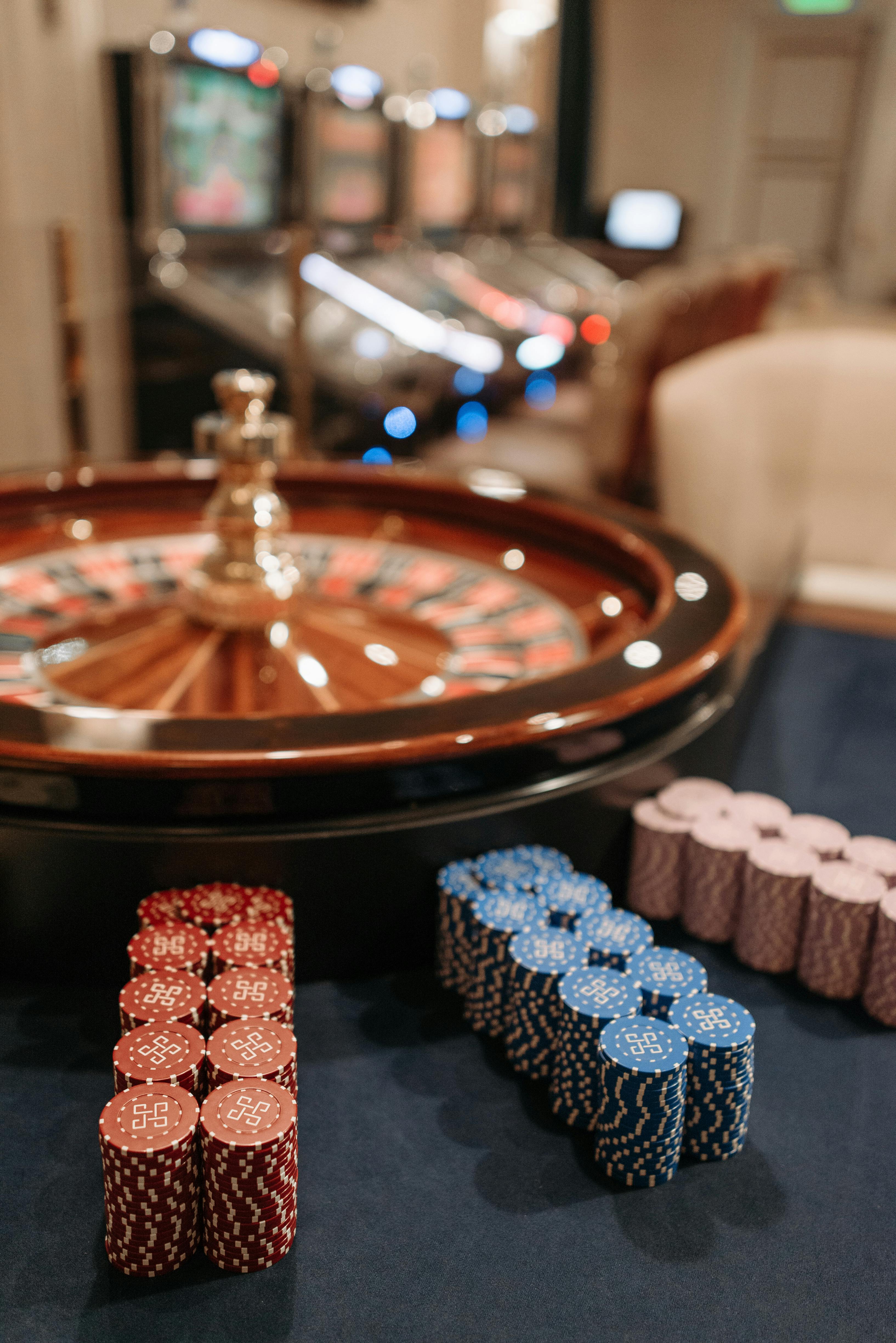 stacks of casino tokens beside a roulette