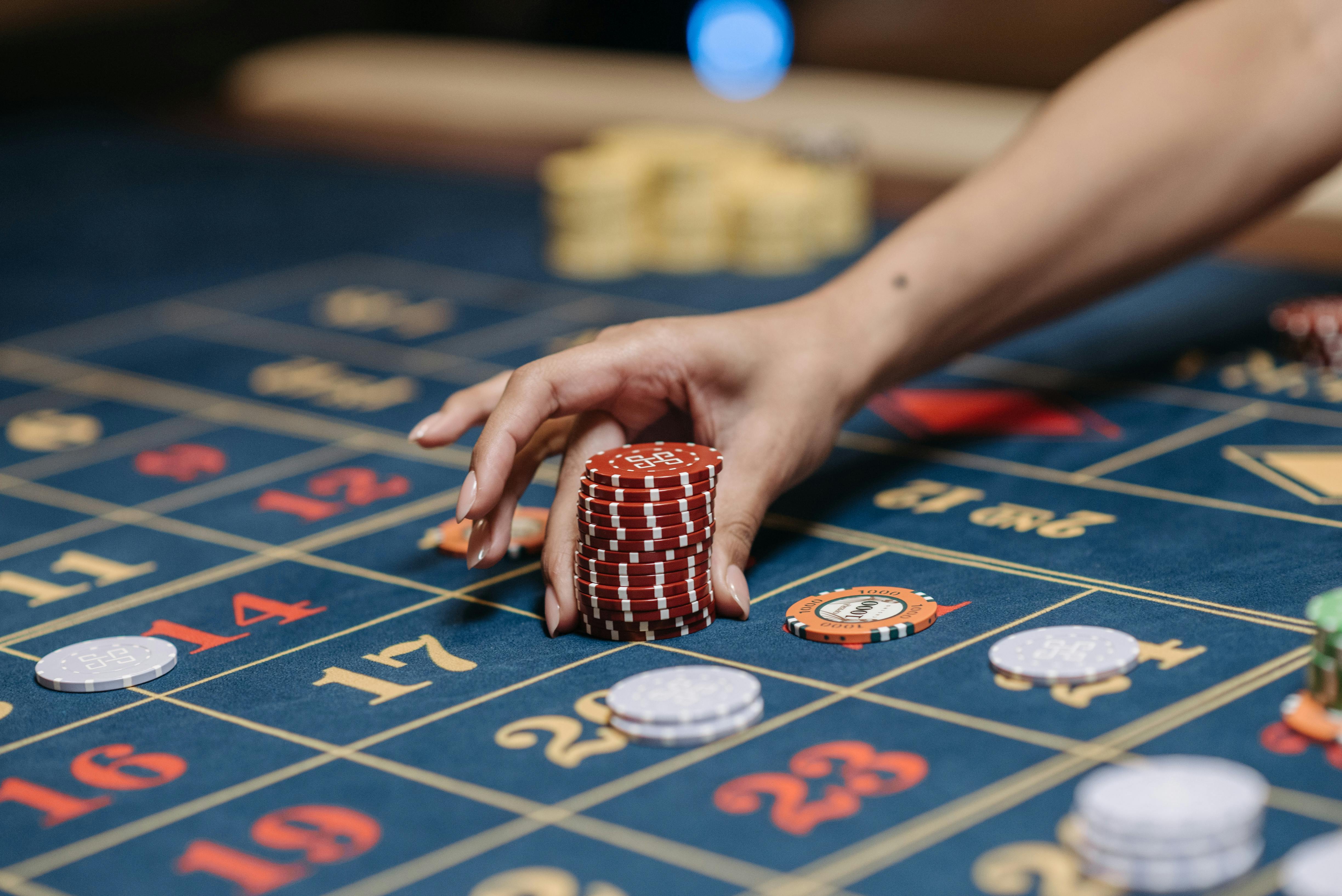 hand holding a red poker chips