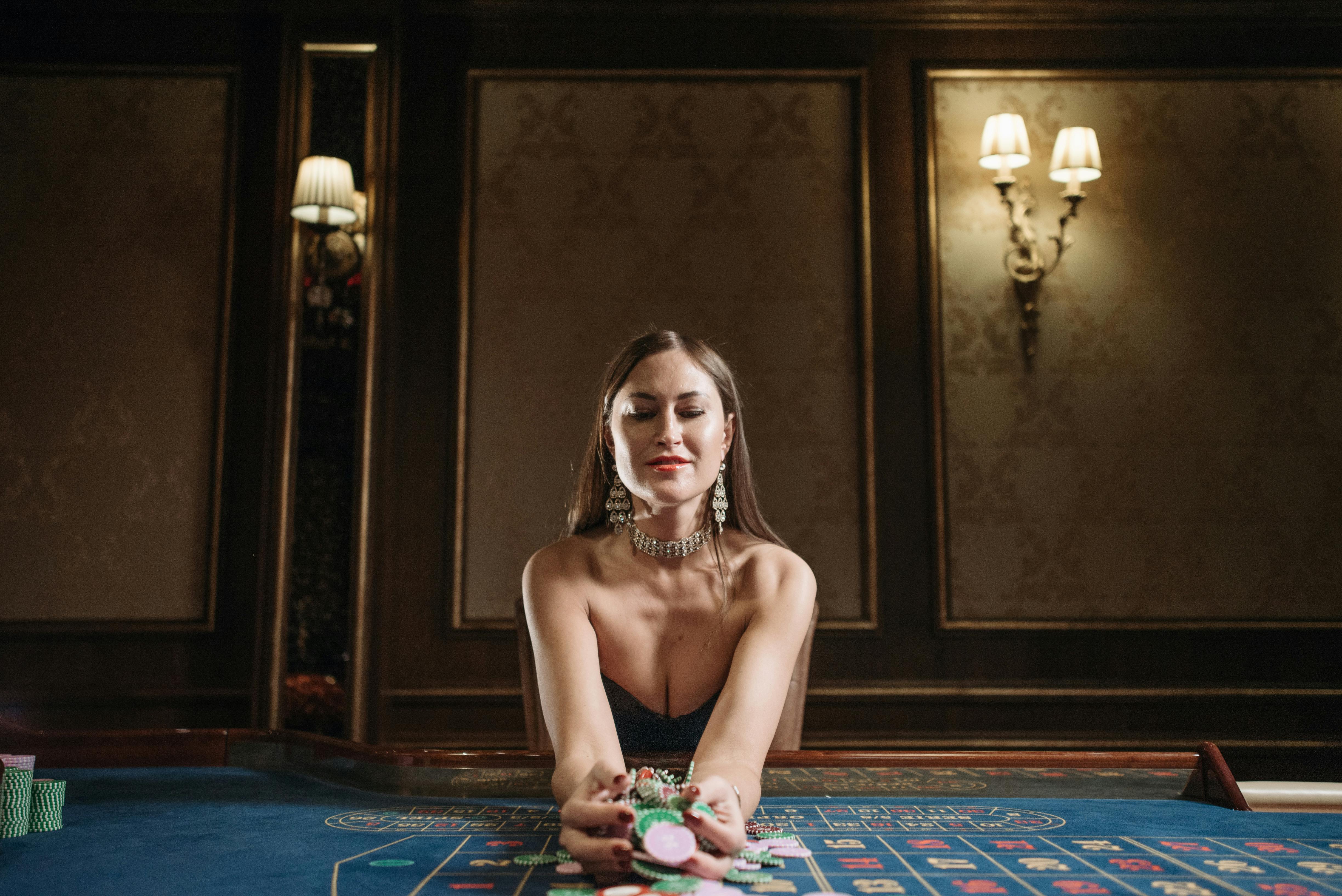 a woman leaning on gaming table holding a bunch of casino tokens