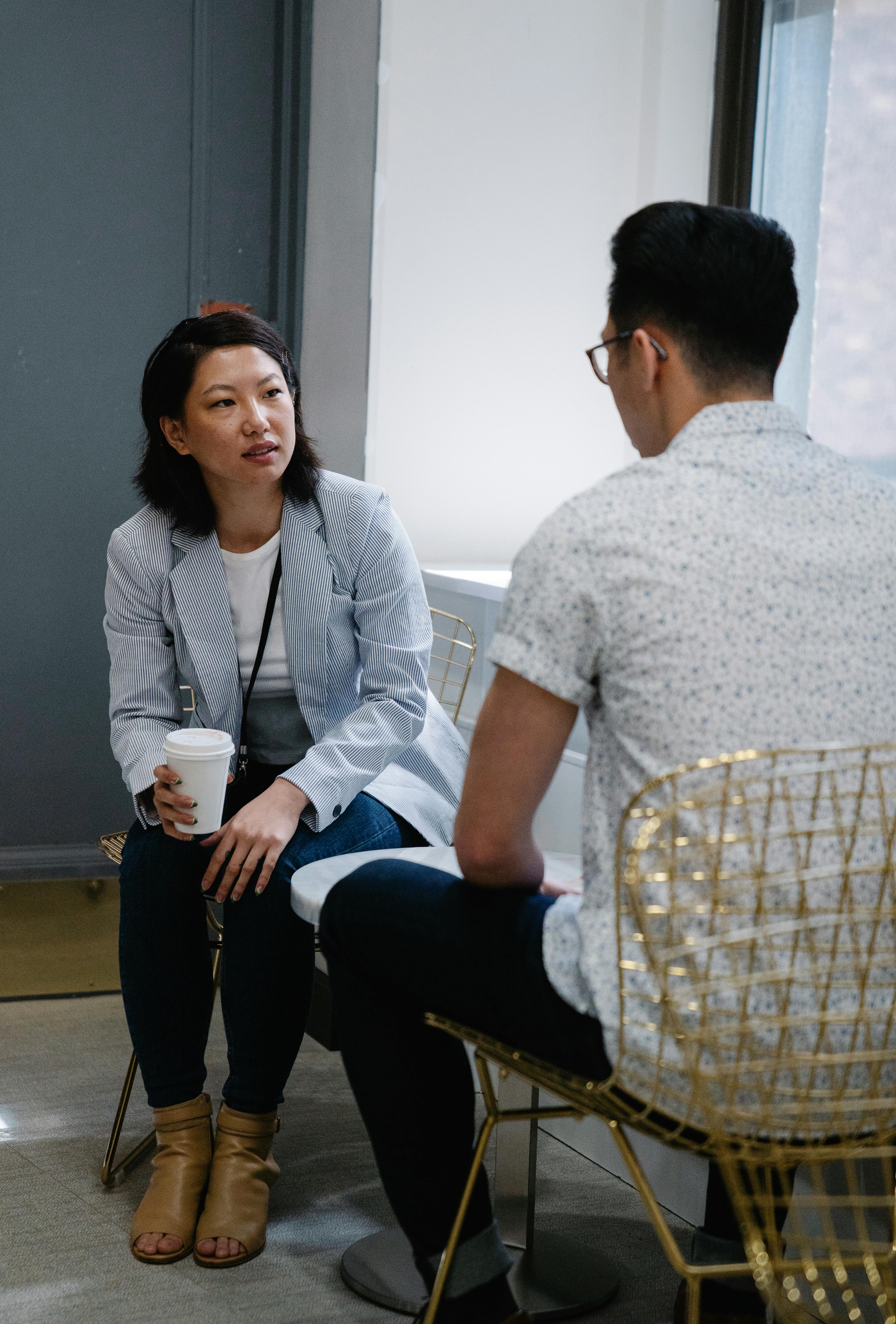 two people sitting and talking at a cafe