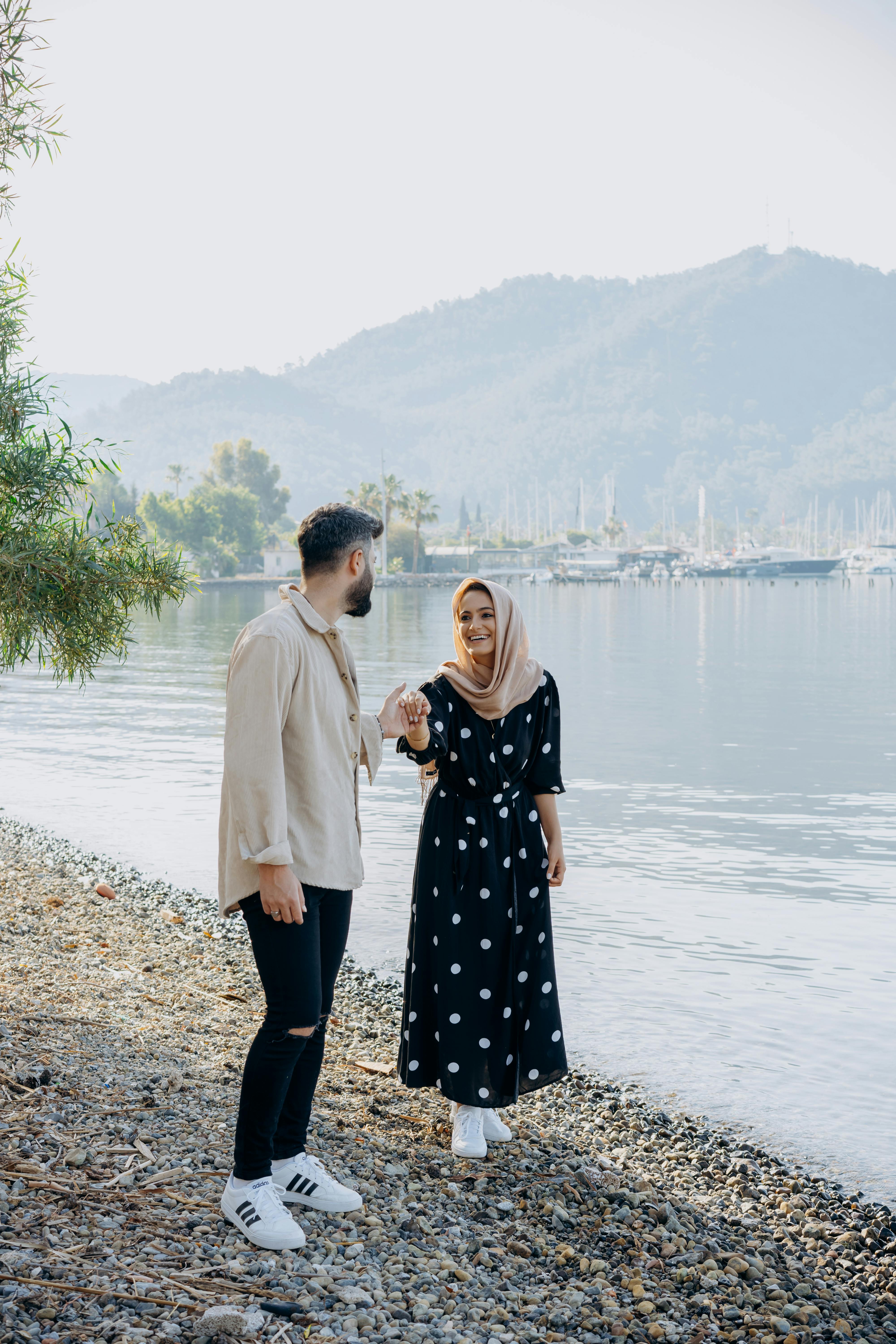 man and woman walking on shore