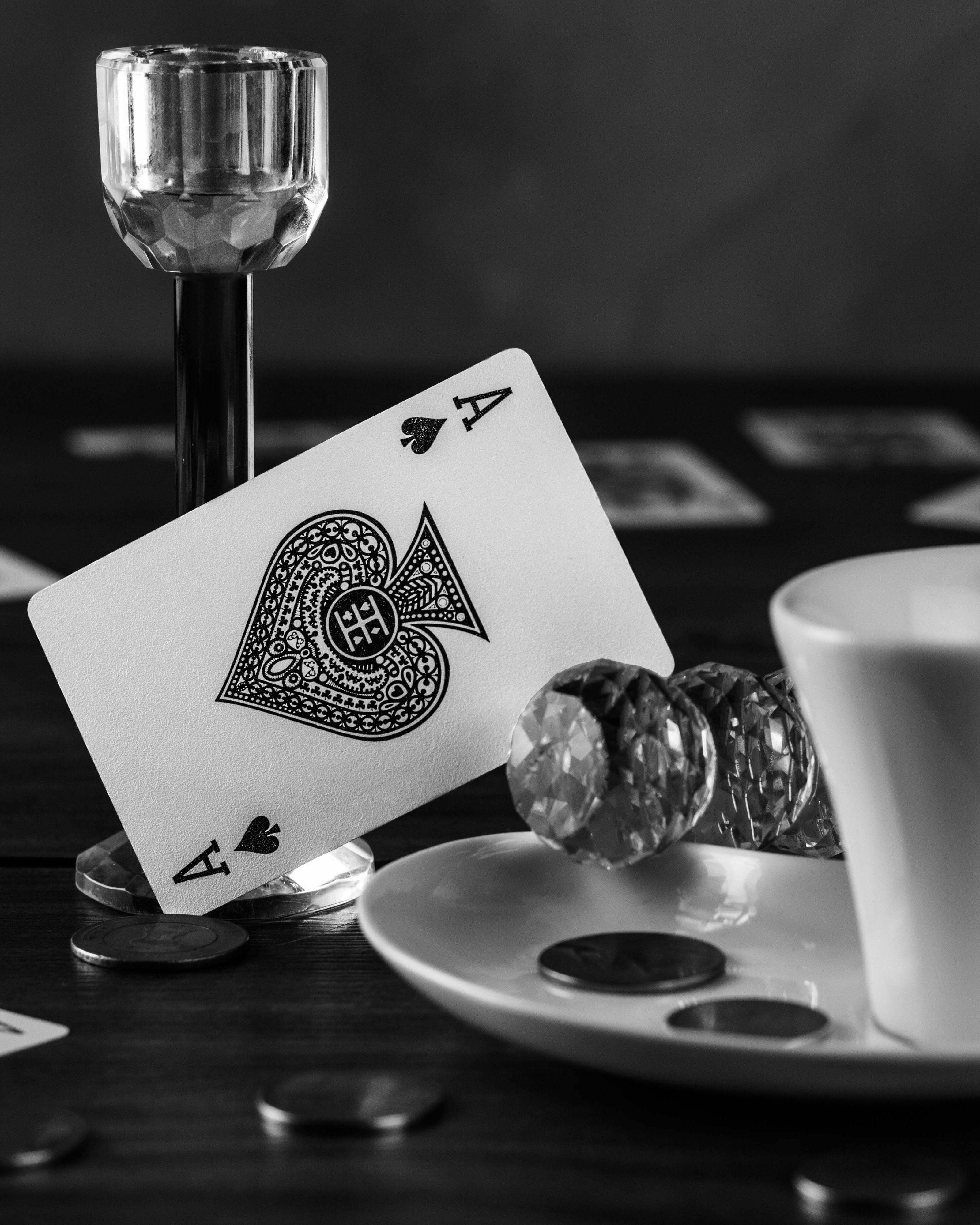 black and white still life with drinking glass and playing card