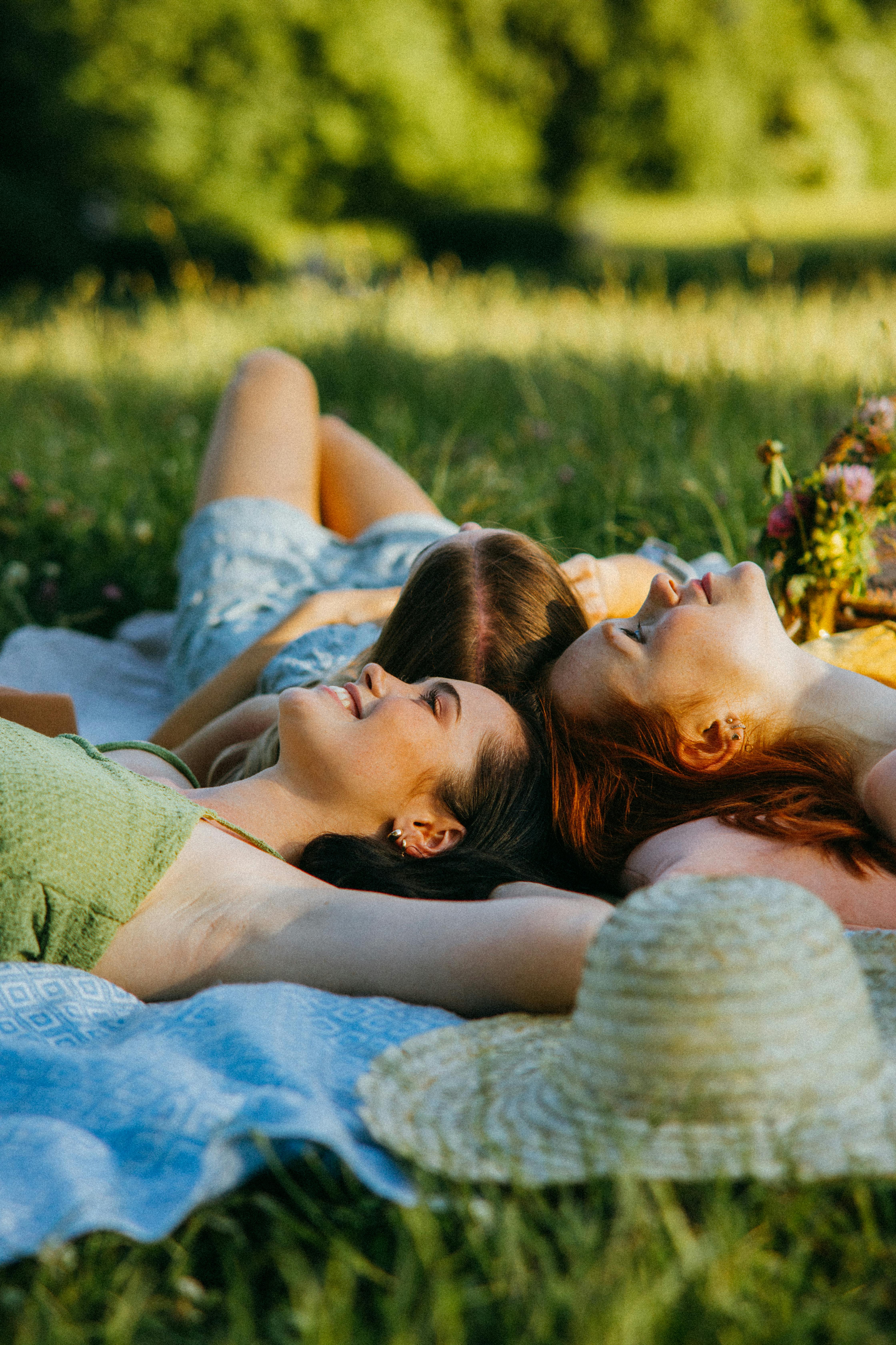 smiling women lying on the picnic blanket