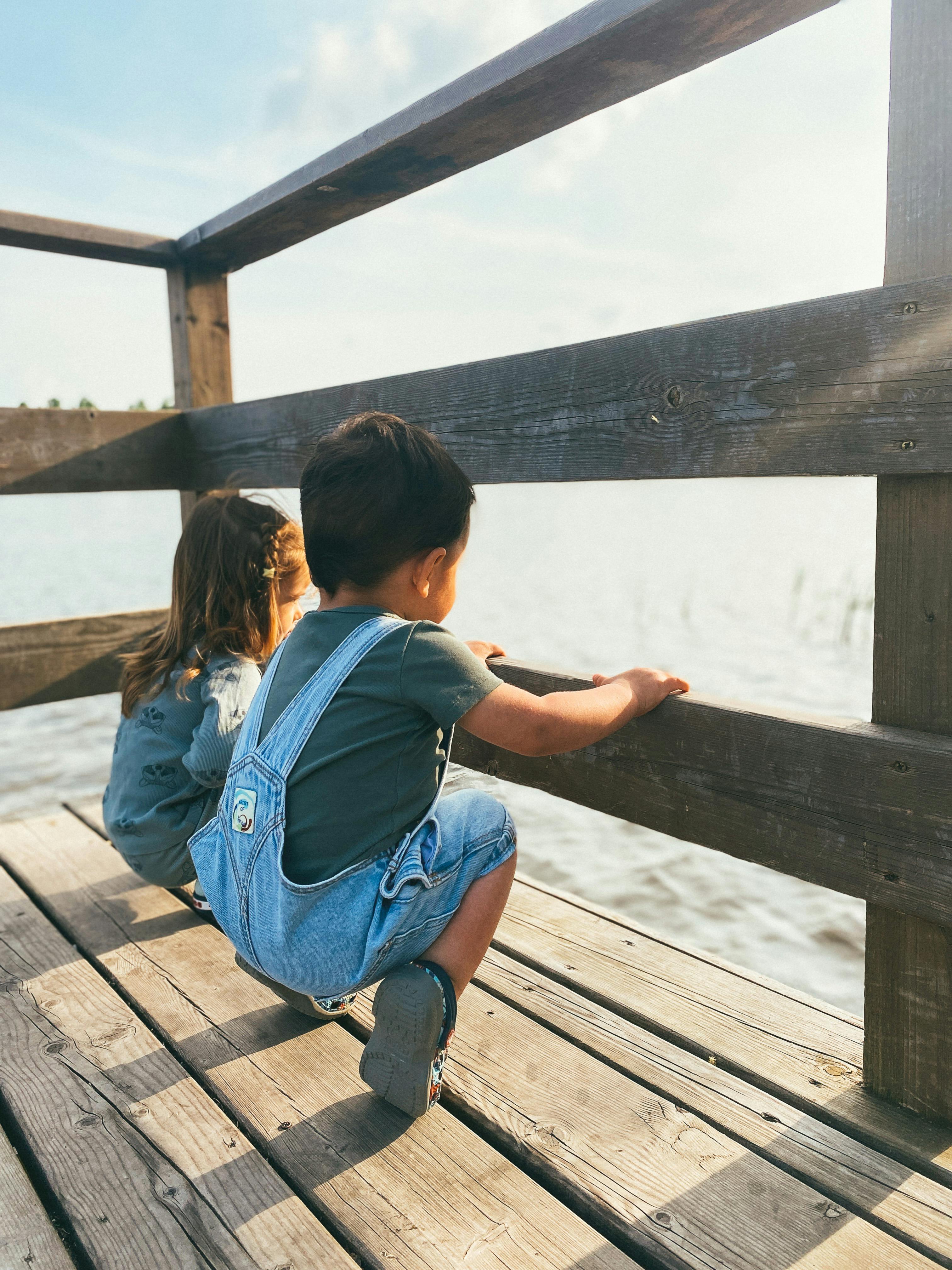 little boy and girl on a wooden pier