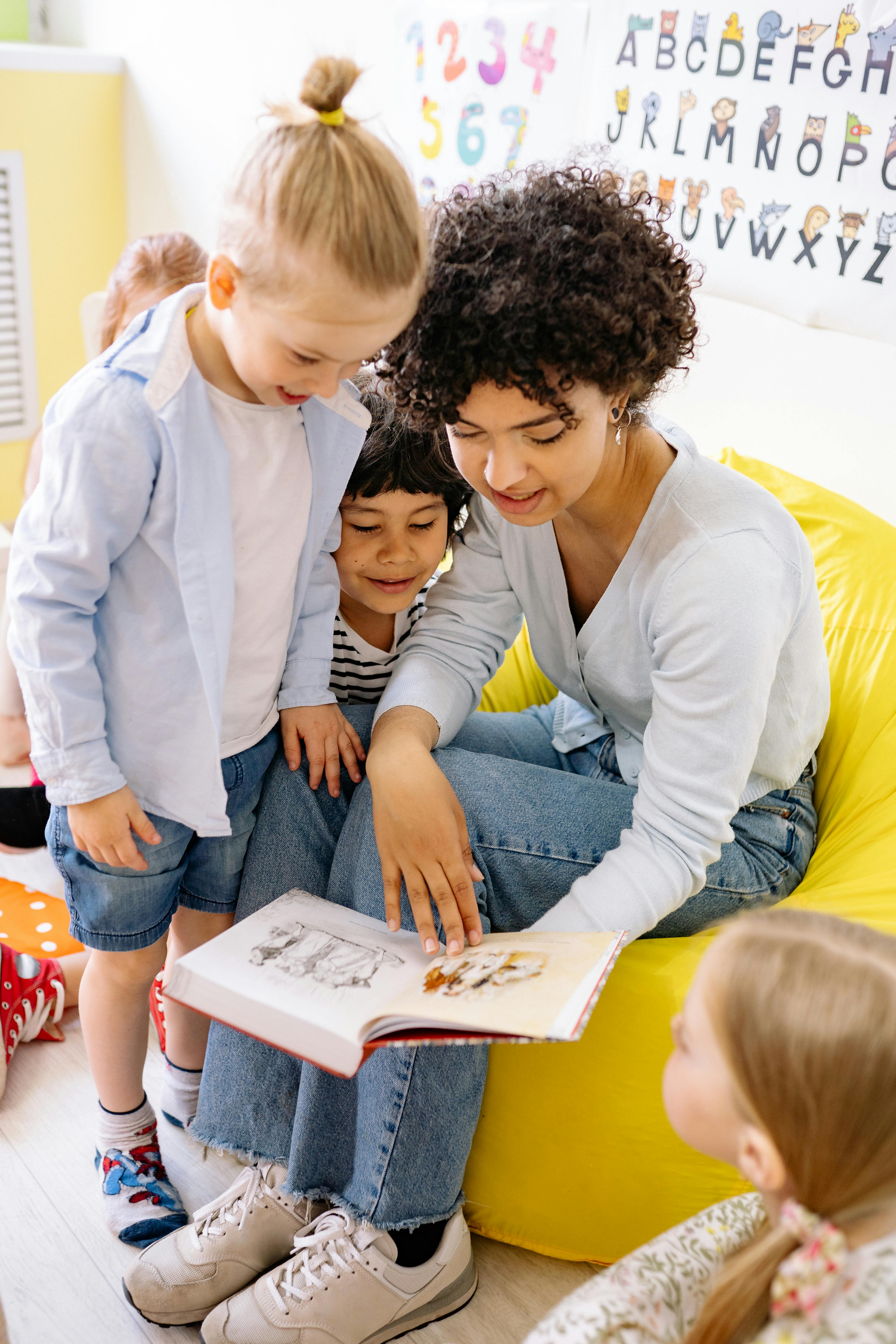 school teacher showing a book to the children