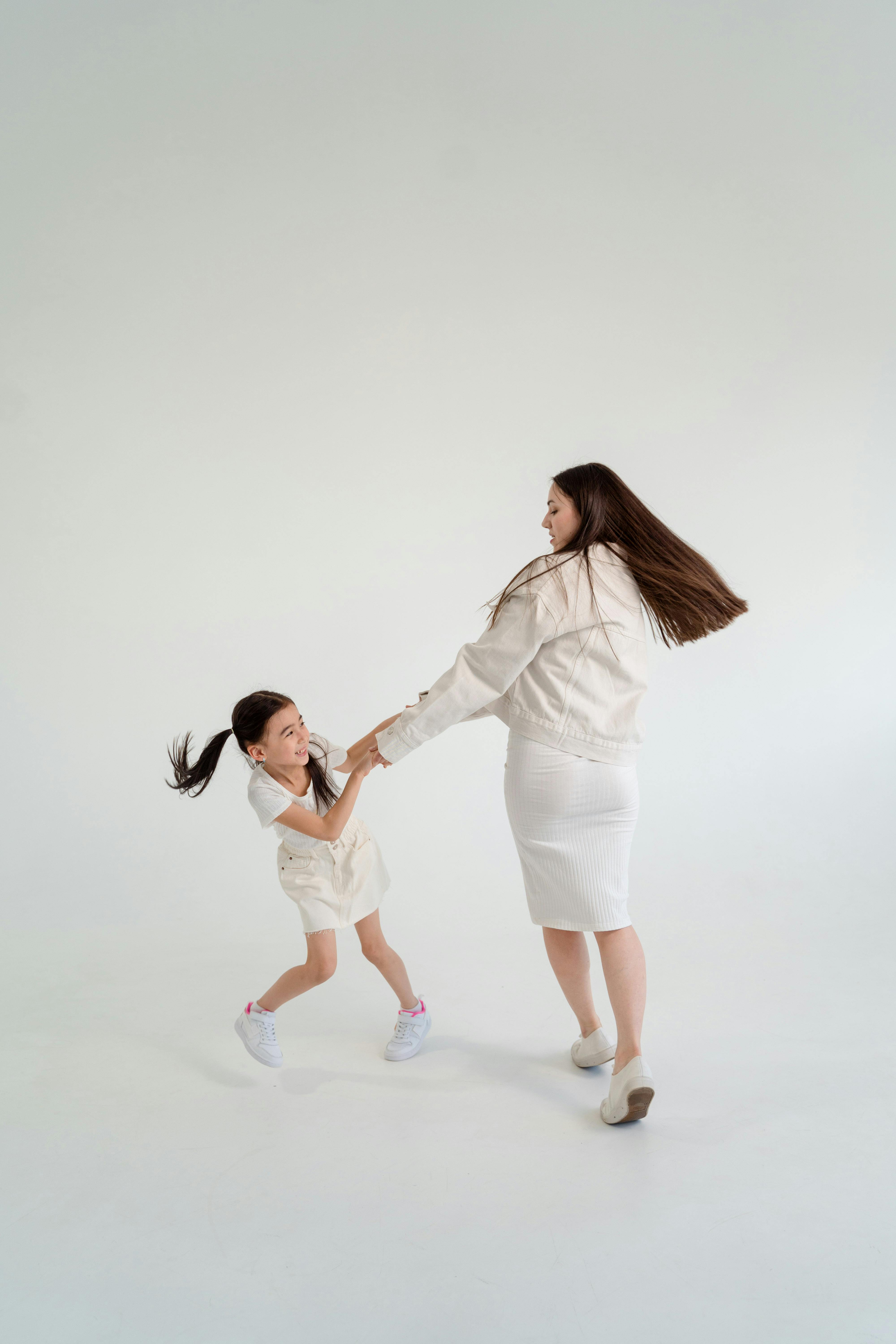 2 girls in white dress shirt and white pants