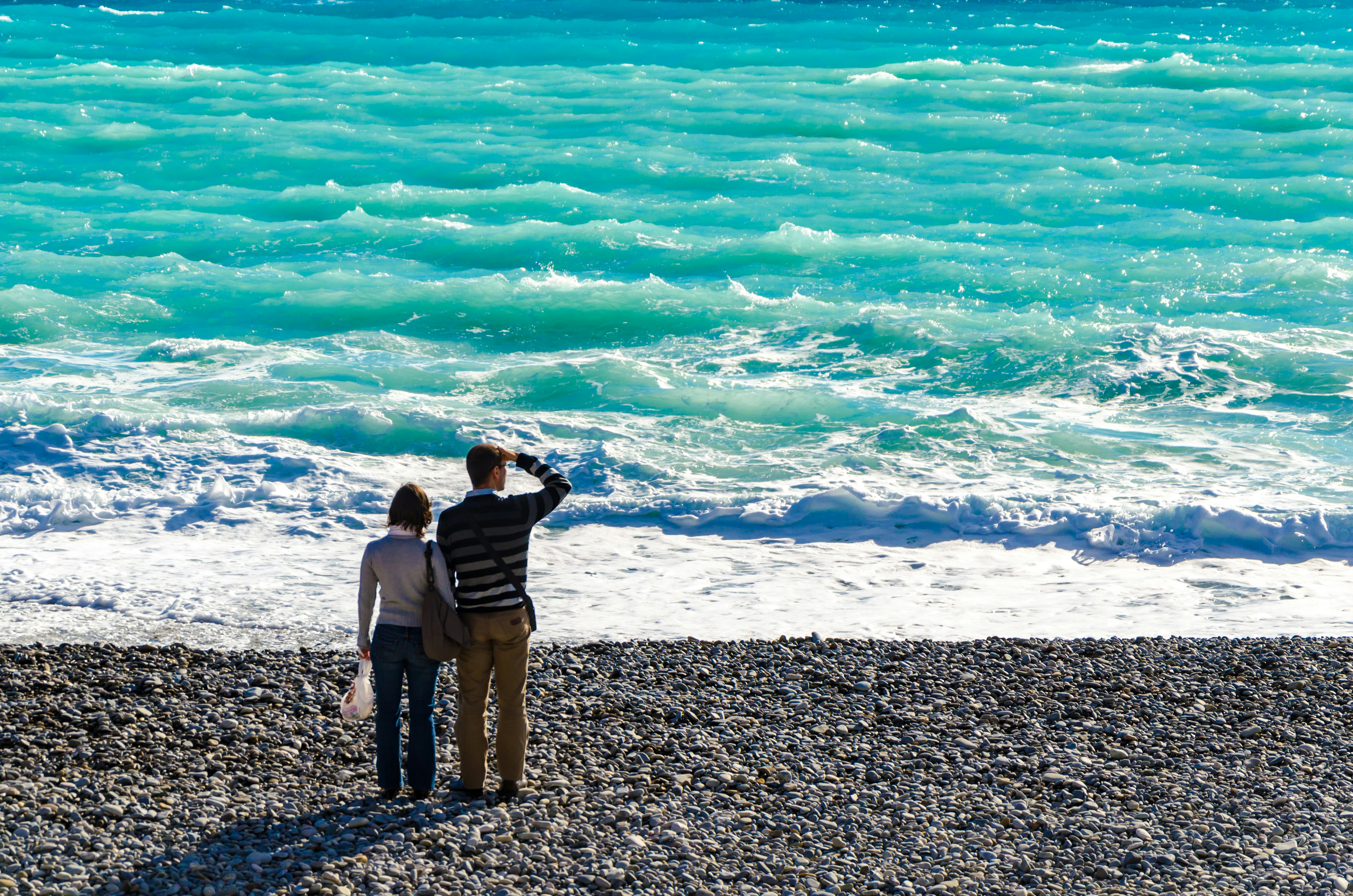 man standing beside woman on shore