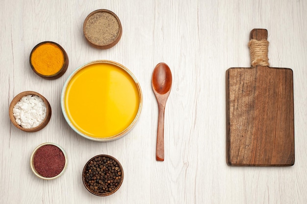 Free photo top view of tasty pumpkin soup cream textured with seasonings on white table