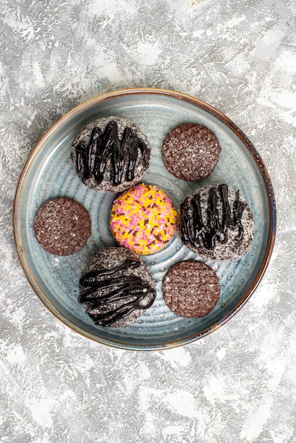 Free photo top view of delicious chocolate balls cakes with cookies on a white surface