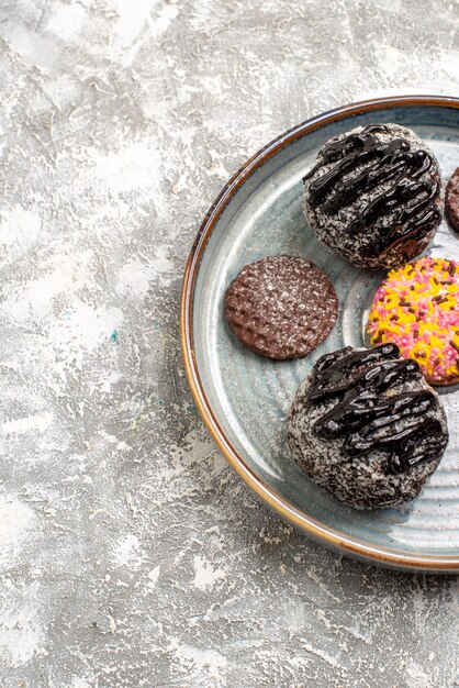 Free photo top view of delicious chocolate balls cakes with cookies on white surface