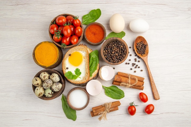 Free photo top view egg toasts with seasonings and tomatoes on white background photo morning meal breakfast food lunch salad color