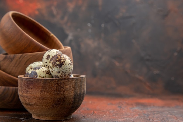 Free photo top view of farm fresh eggs in wooden bowls on the the right side on a brown background