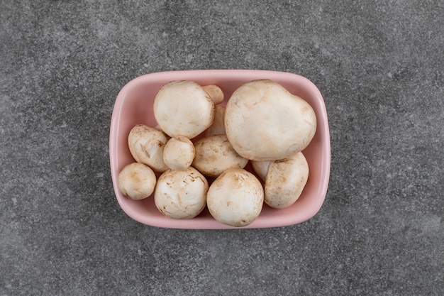 Free photo top view . pile of fresh organic mushrooms in pink bowl