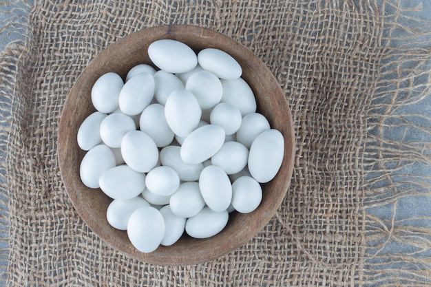 Free photo white candies in the cup on the trivet, on the marble table.