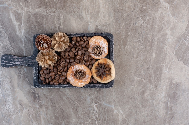 Free photo anise, cookies, coffee beans and pine cones on marble.