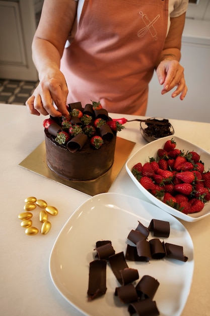 Free photo female confectioner with chocolate cake in the pastry shop