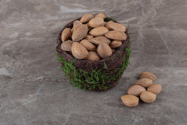 Free photo flavorful almonds in a bowl on the marble surface