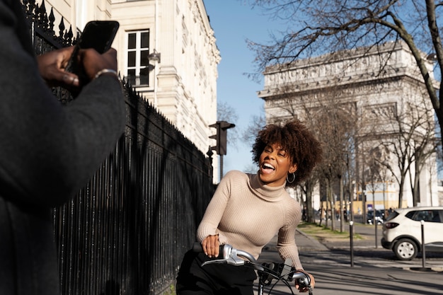 Free photo man taking photo of woman riding the bike in the city in france