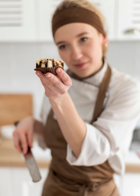 Free photo medium shot cook holding cookie