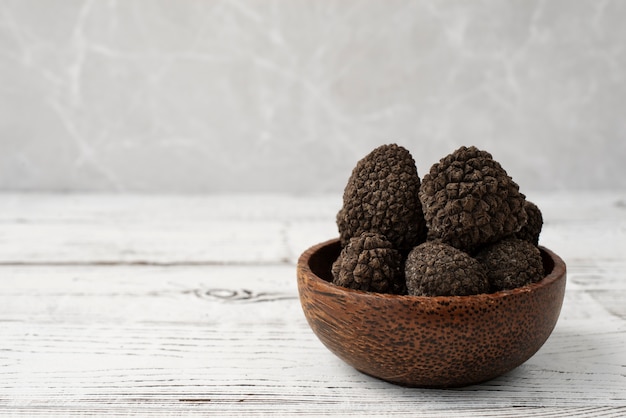 Free photo raw truffles in bowl on wooden table