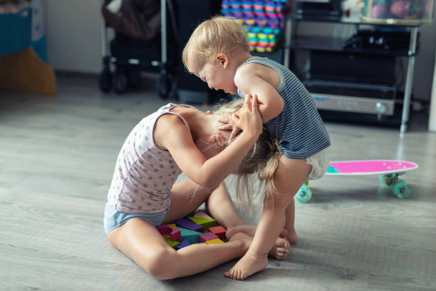 zwei kleine geschwister kinder streiten sich nach dem spielen im zimmer im haus. weinen beleidigt kleinkind junge streit mit älteren schwester. familienrivalität und generationenkonfliktkonzept - fight friend stock-fotos und bilder