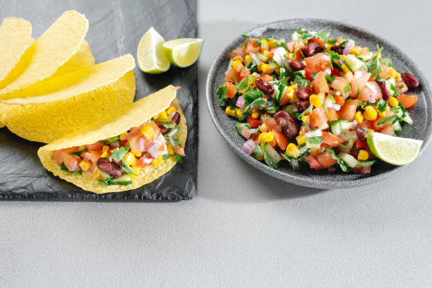 Salsa with corn and beans on a wooden backdrop with tacos. Mexican Cuisine. Empty space for the text. Copy space. Salsa with corn and beans on a wooden backdrop with tacos. Mexican Cuisine. Empty space for the text. Copy space tuber magnatum pico stock pictures, royalty-free photos & images