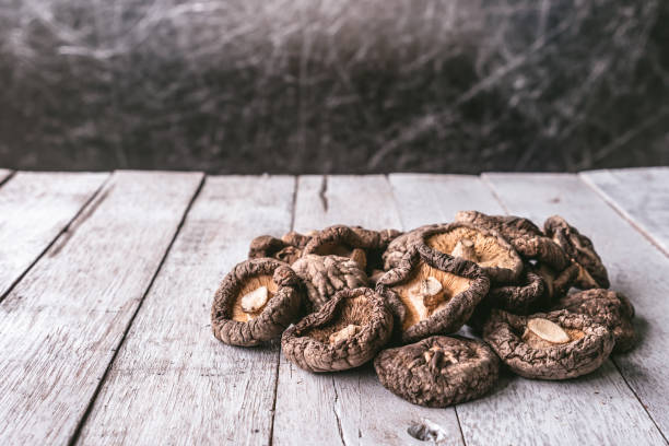 setas shiitake seco en la mesa de madera. - трюфели ползи fotografías e imágenes de stock