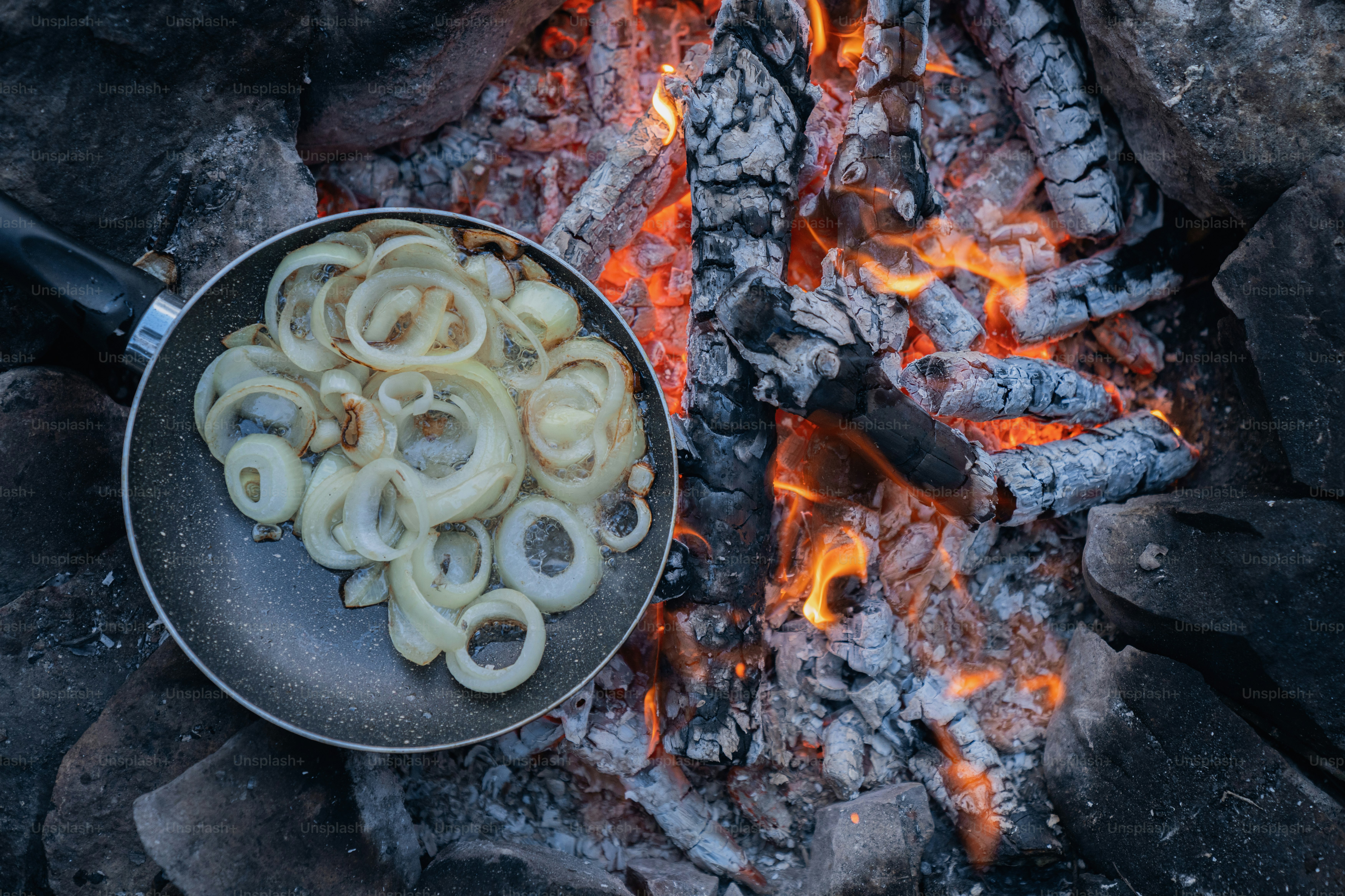 a frying pan filled with food sitting on top of a fire