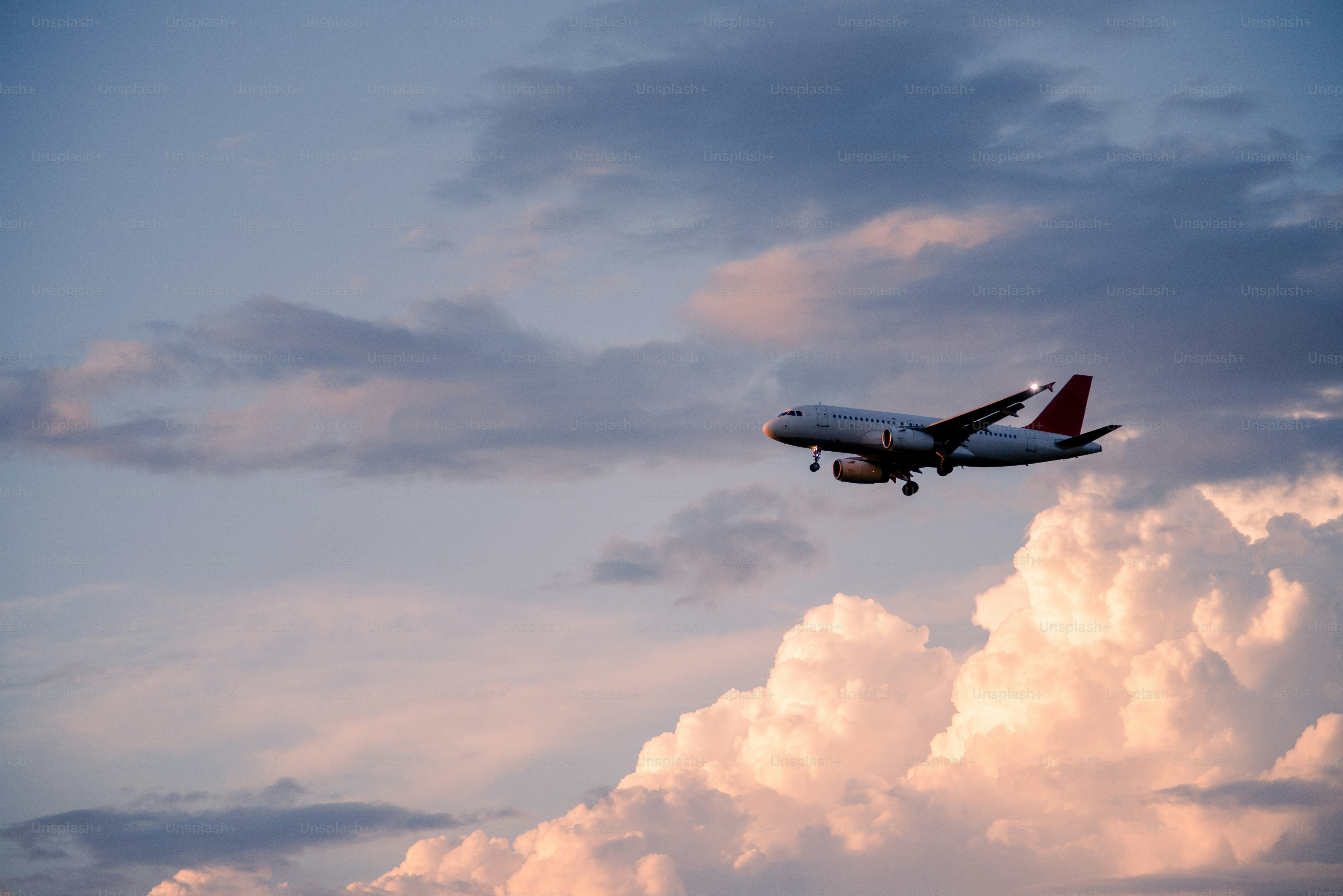 Plane landing or taking off with open landing gear on a beautiful sunset or sunrise colorful sky